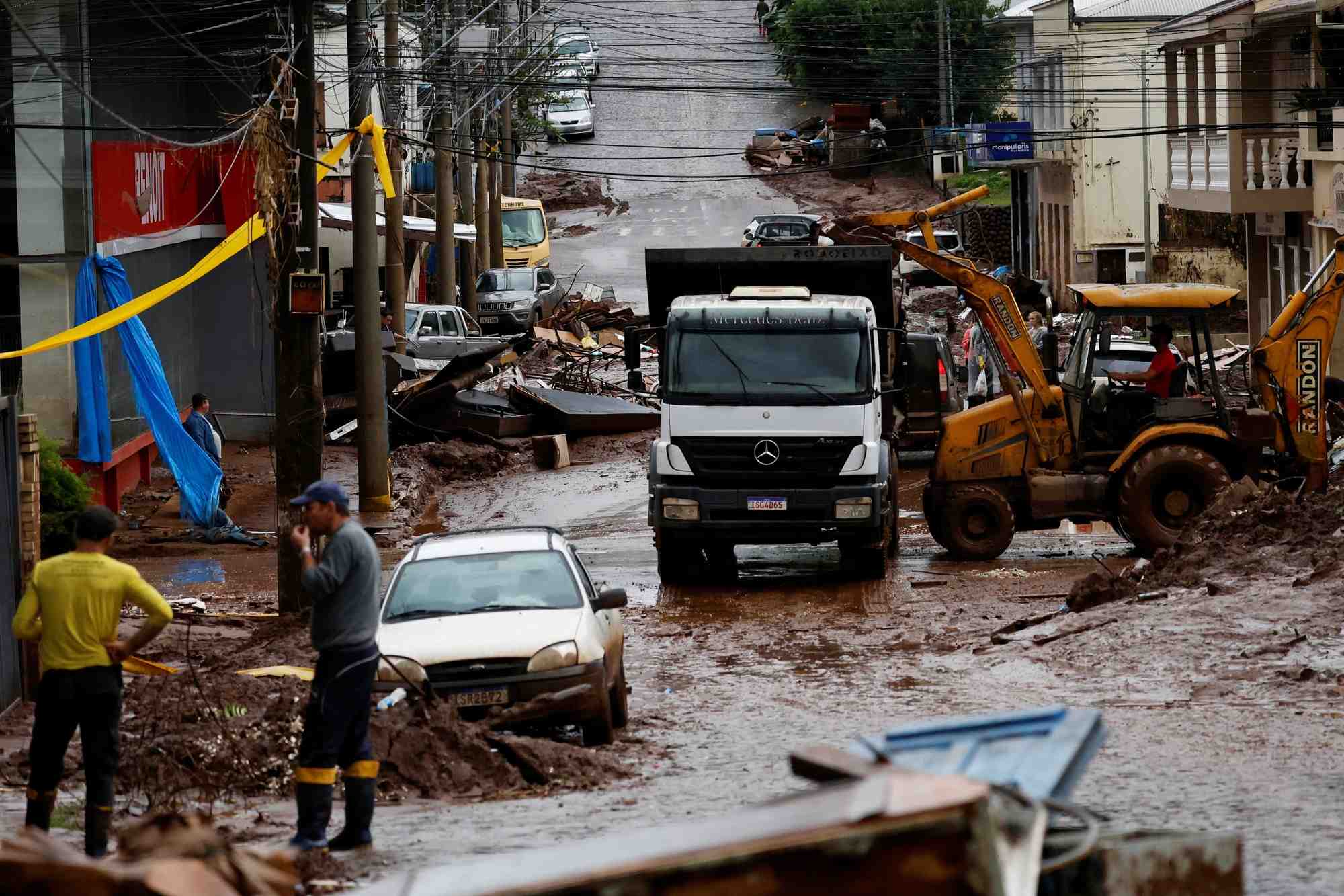 Des personnes aident a nettoyer des maisons partiellement detruites par les inondations a mucum, dans l'etat du rio grande do sul