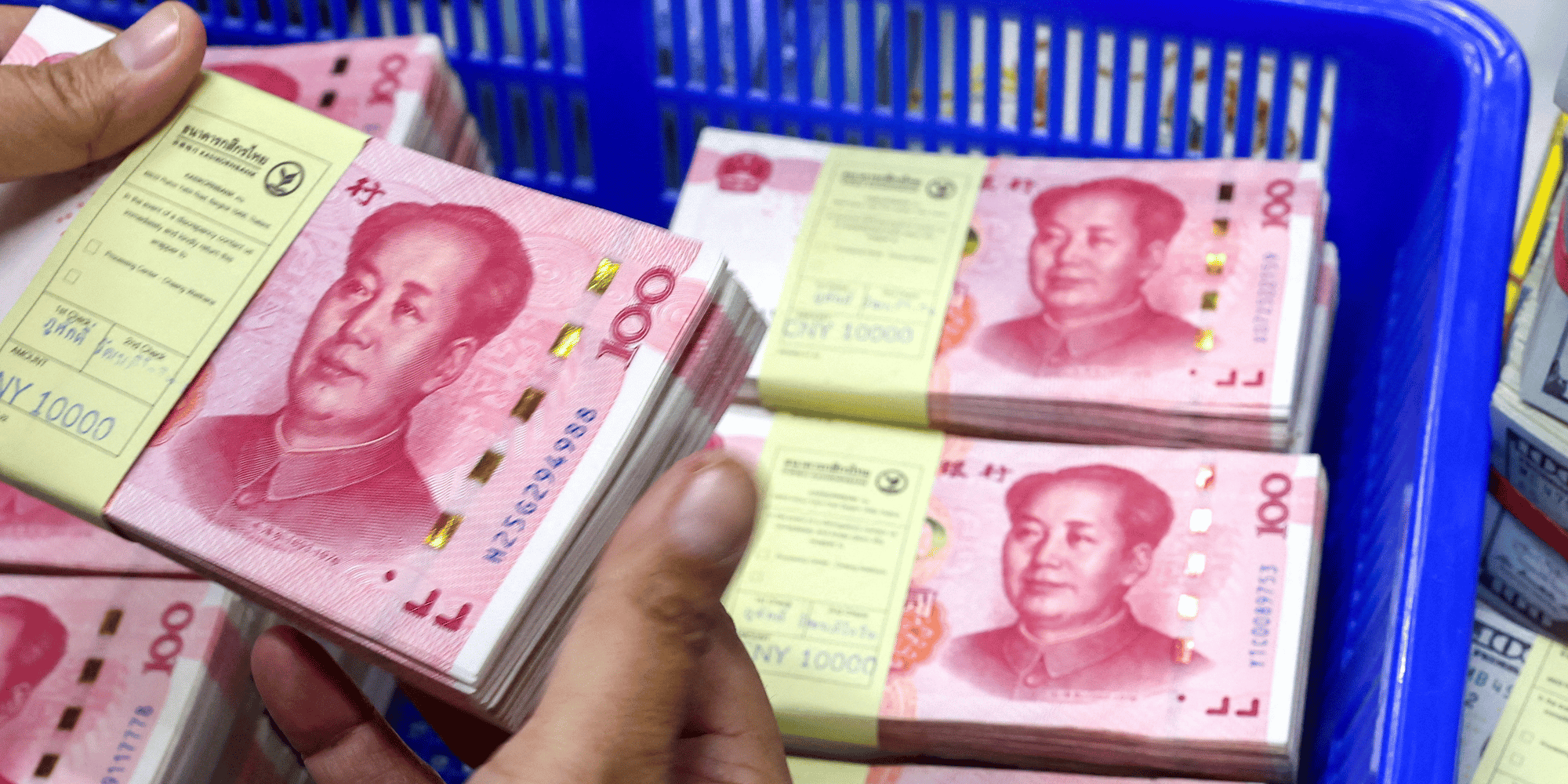 Un employe de banque compte les billets en renminbi (rmb) ou yuan de la chine a cote des billets en dollars americains dans une kasikornbank a bangkok
