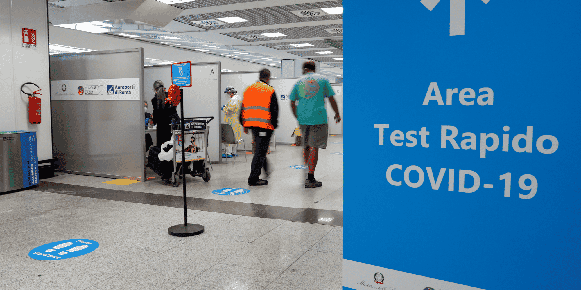 Des personnes marchent a cote d'un site de tests de depistage du covid-19 a l'aeroport de fiumicino