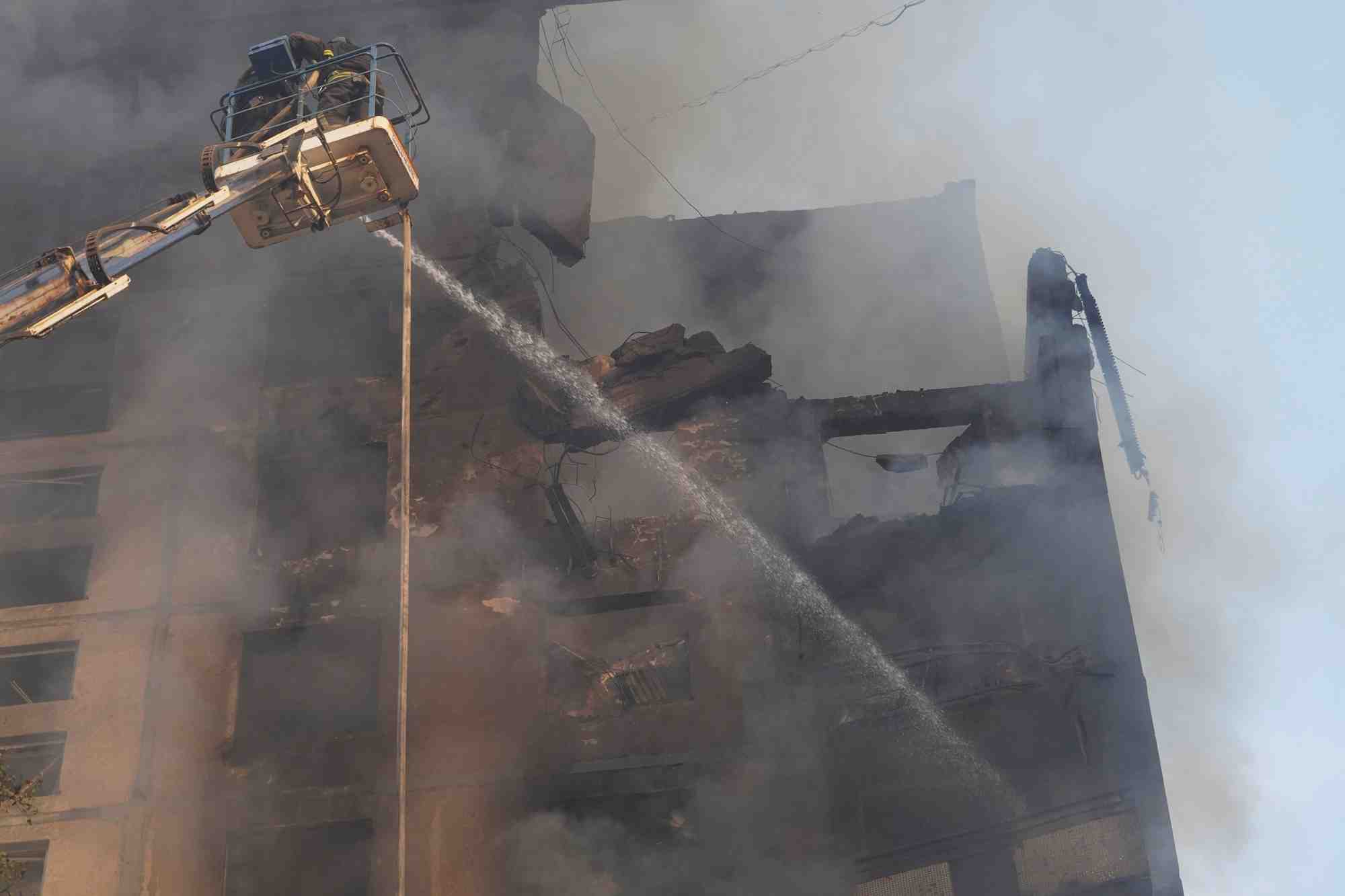 Pompiers sur le site d'un immeuble d'habitation touche par une frappe aerienne russe, a kharkiv