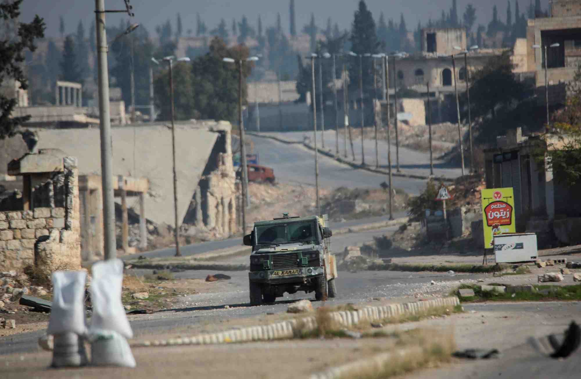 Des rebelles menes par le groupe militant islamiste hayat tahrir al-sham circulent dans une rue d'al-rashideen, dans la province d'alep