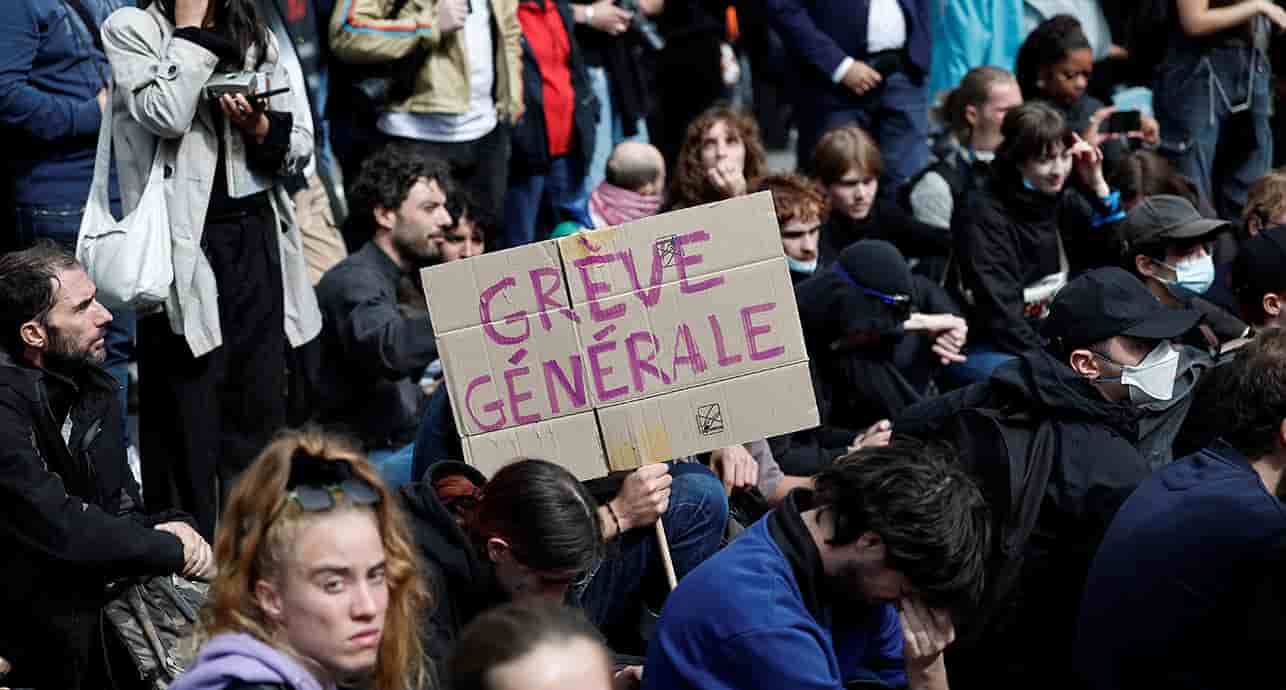 Des manifestants brandissent une pancarte "Grève générale" lors d'une mobilisation syndicale devant la Gare du Nord, à Paris.