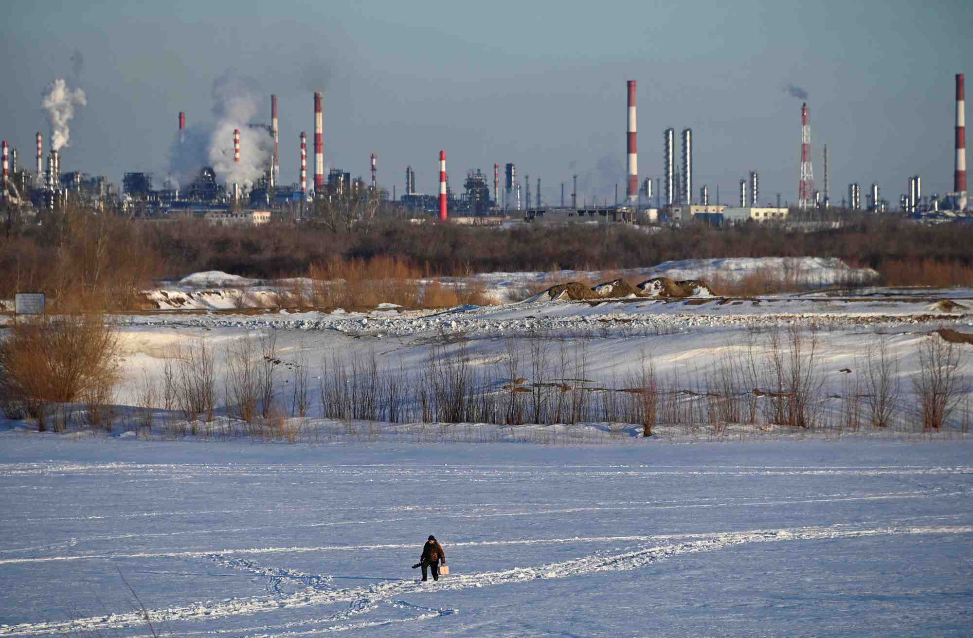 Un homme marche pres d'une raffinerie de petrole a omsk, en russie