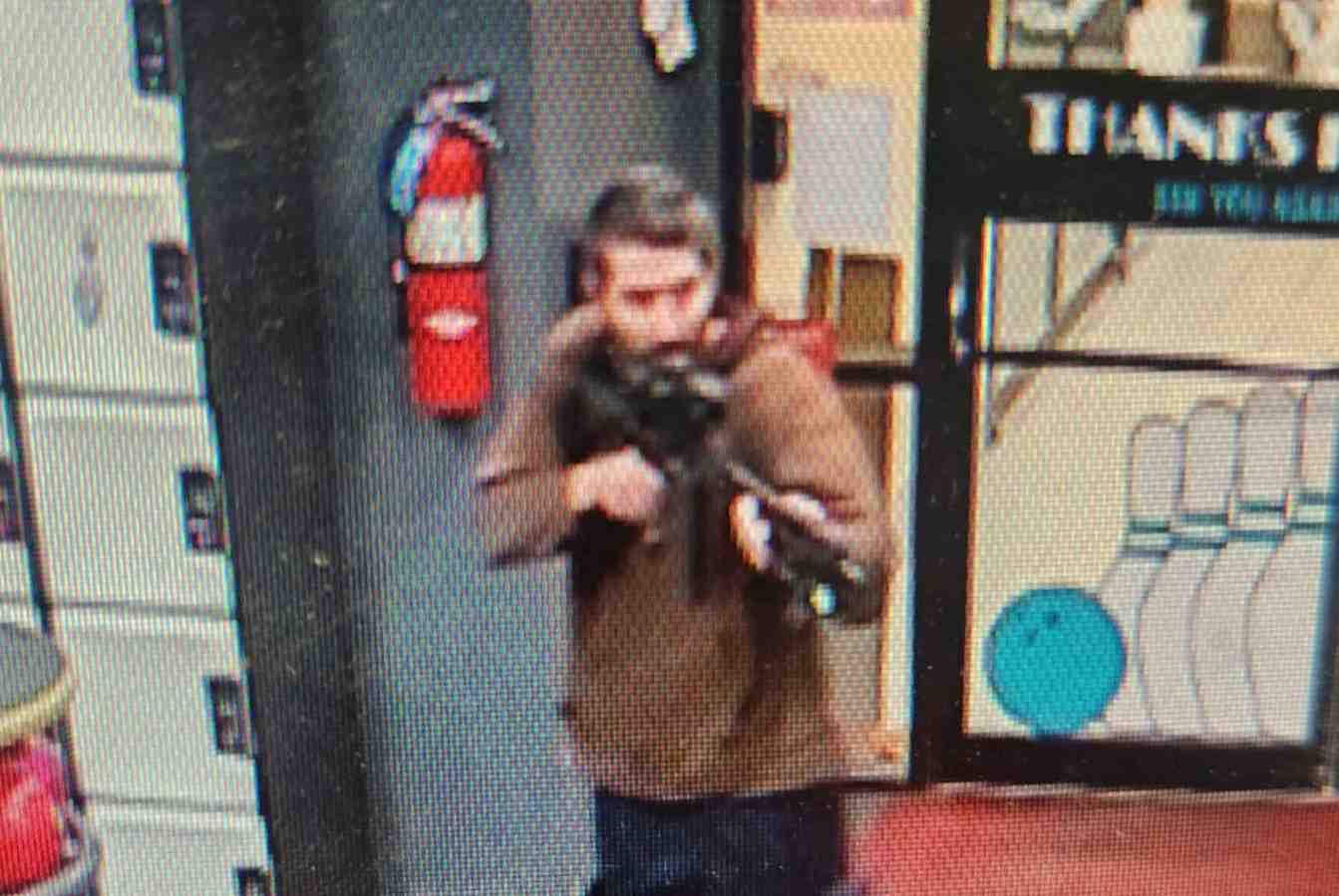 Un homme identifie comme suspect par la police pointe ce qui semble etre un fusil semi-automatique, a lewiston