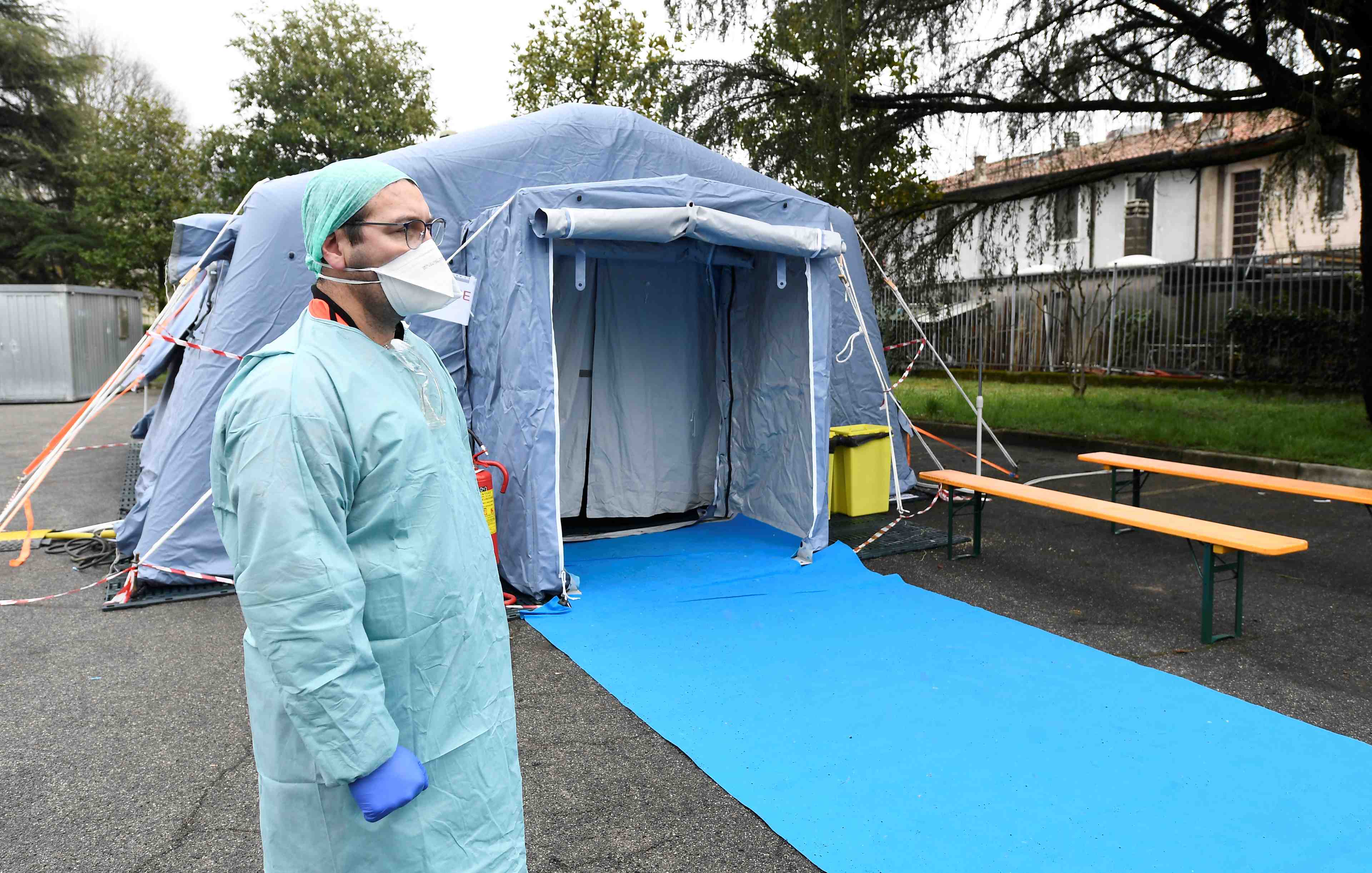 Coronavirus/Covid-19 : Un soignant portant un masque attend devant un checkpoint médical en Italie