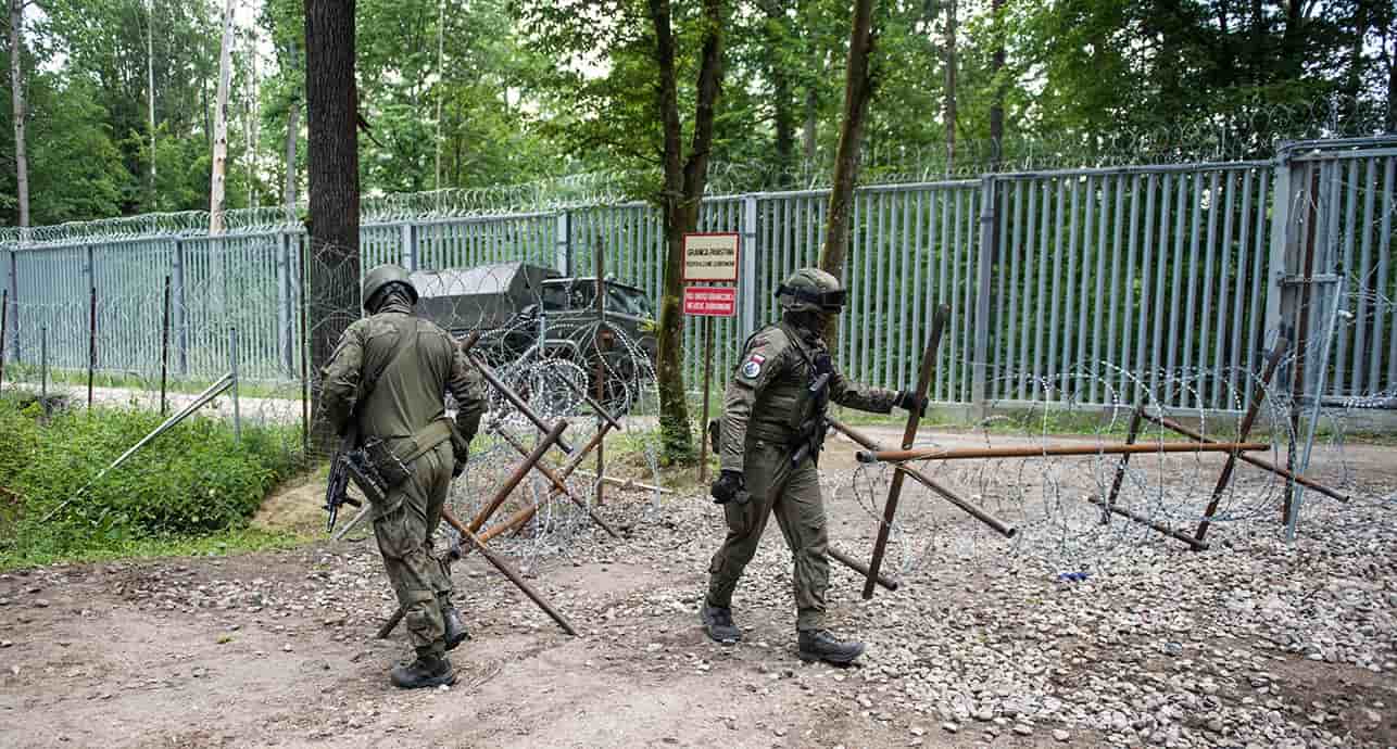 Des soldats polonais patrouillent à la frontière avec la Biélorussie le long de la clôture frontalière dans la forêt de Bialowieza.
