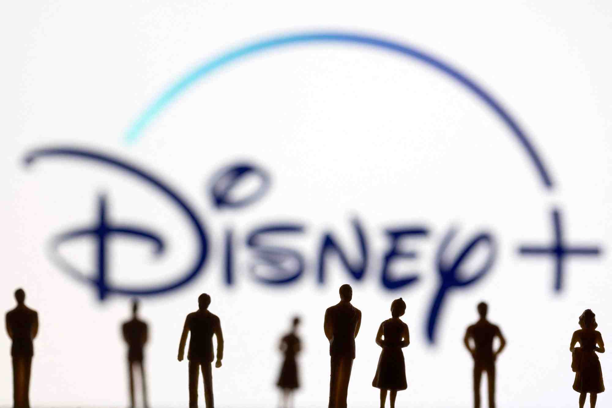 Des figurines sont vues devant le logo de disney+