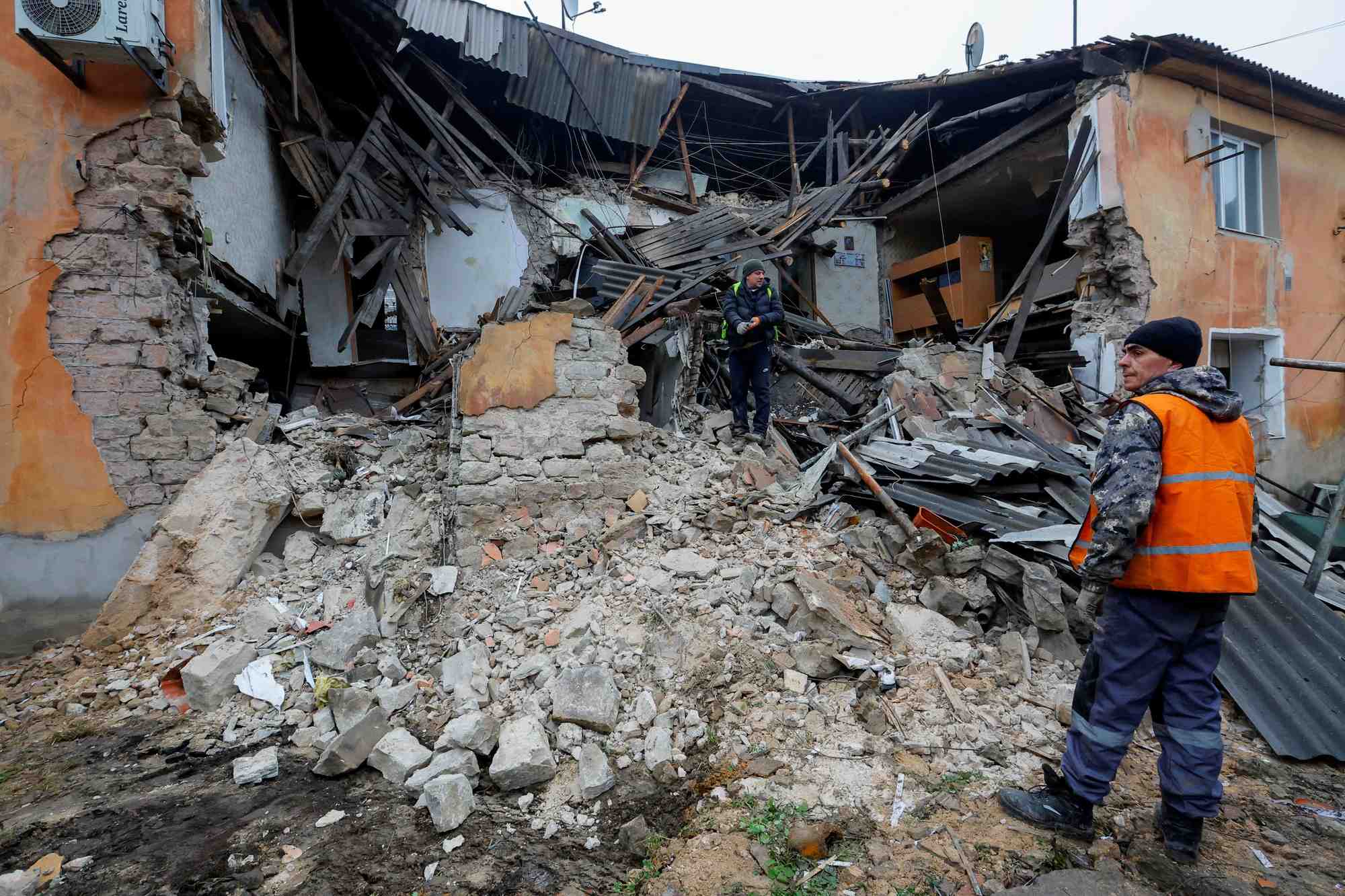 Des ouvriers enlevent les debris d'un batiment residentiel endommage par un bombardement a horlivka