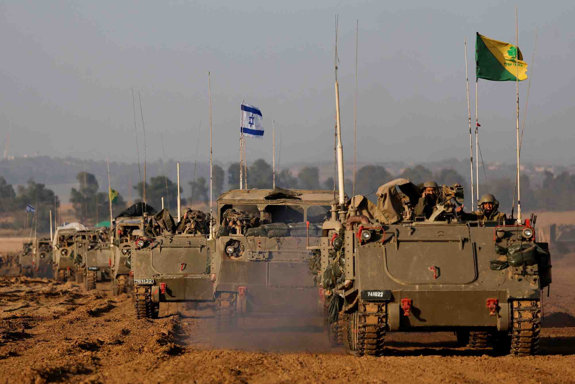 Un convoi israelien de chars et de vehicules blindes de transport de troupes passe la frontiere israelienne