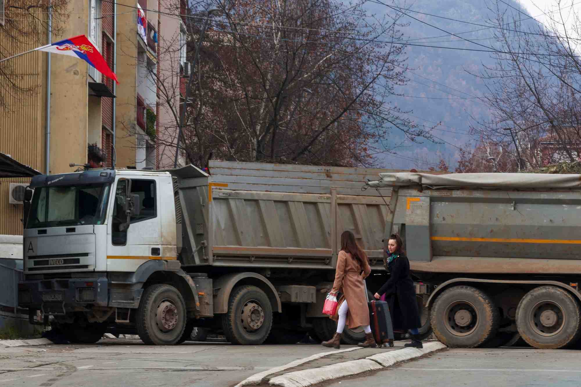 Des habitants marchent pres d'un barrage routier dans la partie nord de la ville ethniquement divisee de mitrovica
