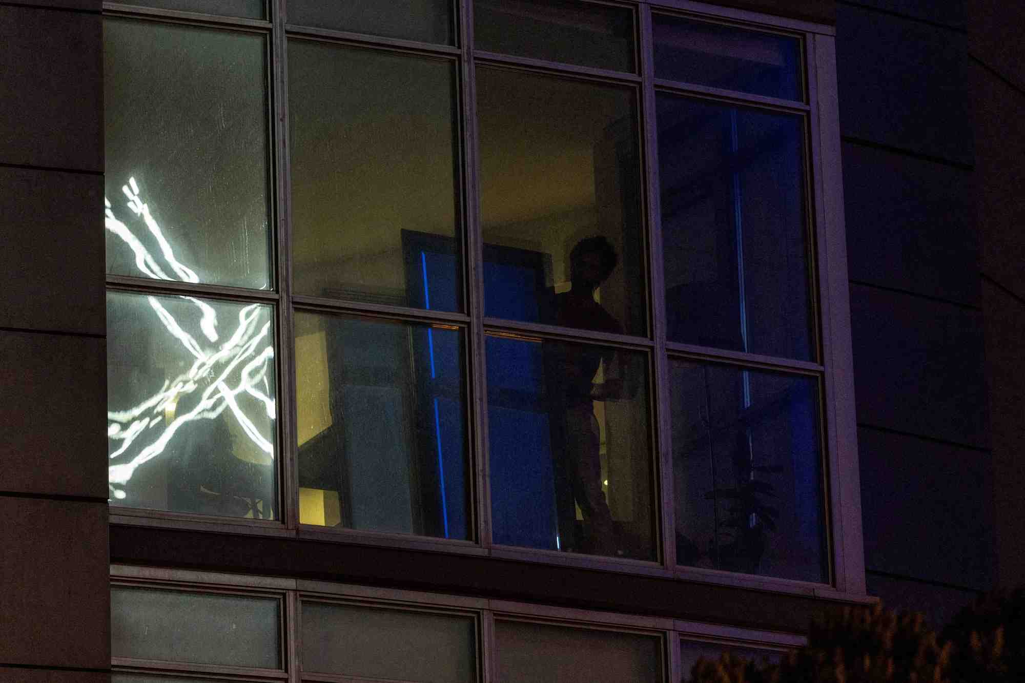 Le logo « x » se reflete sur la fenetre d'un appartement