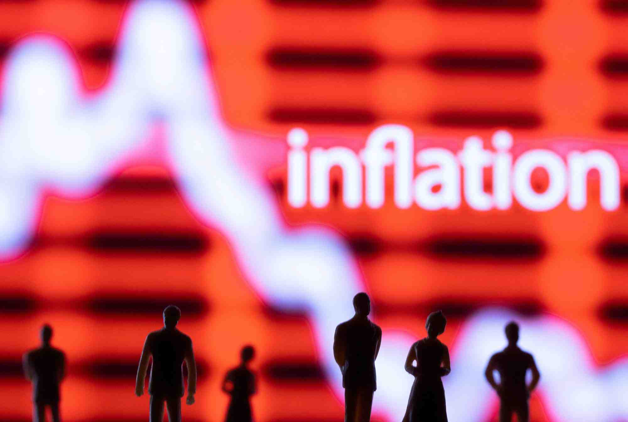 Photo d'illustration de figurines devant un graphique boursier affiche et le mot "inflation"