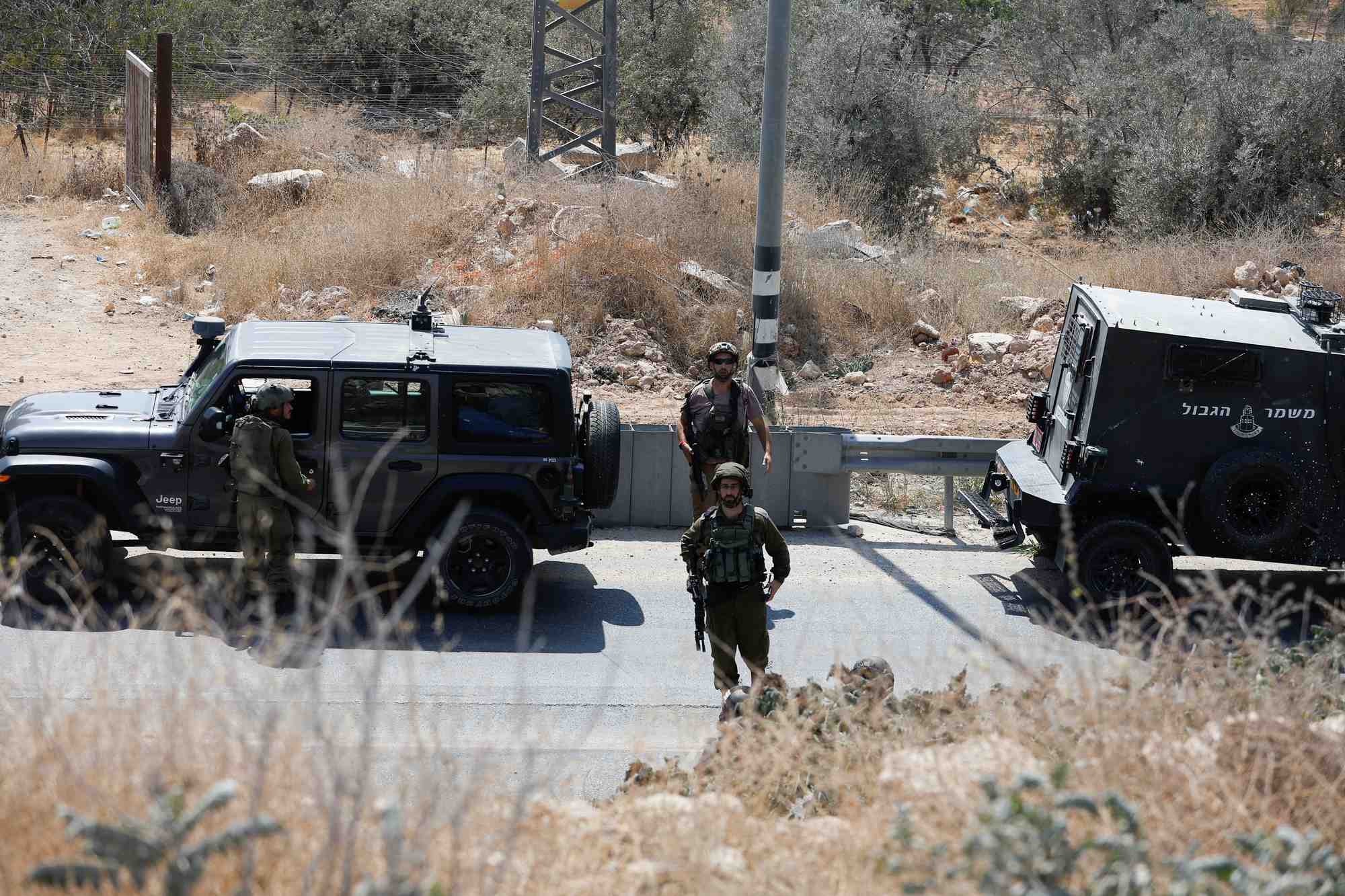 Des soldats israeliens montent la garde sur les lieux d'une fusillade, pres d'hebron, en cisjordanie occupee par israel