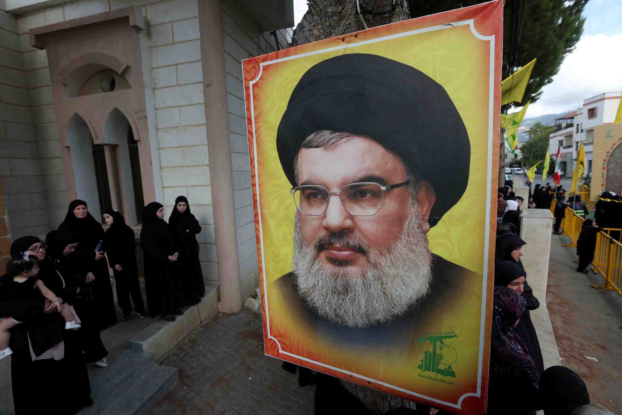Photo de fichier : des personnes se tiennent pres d'une photo du chef du hezbollah, sayyed hassan nasrallah, a kfar melki