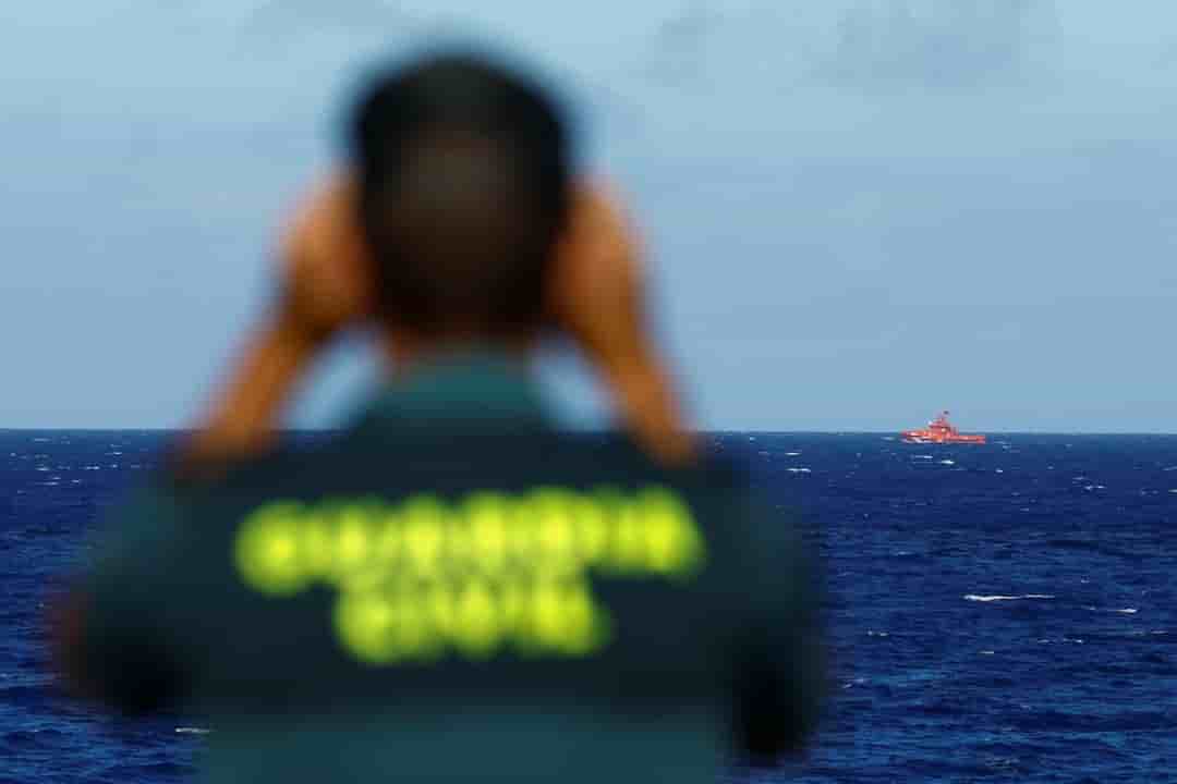 Un officier de la garde civile surveille un bateau de sauvetage a la recherche d'eventuels survivants apres le naufrage d'un bateau en bois transportant des migrants pres du port de la restinga.