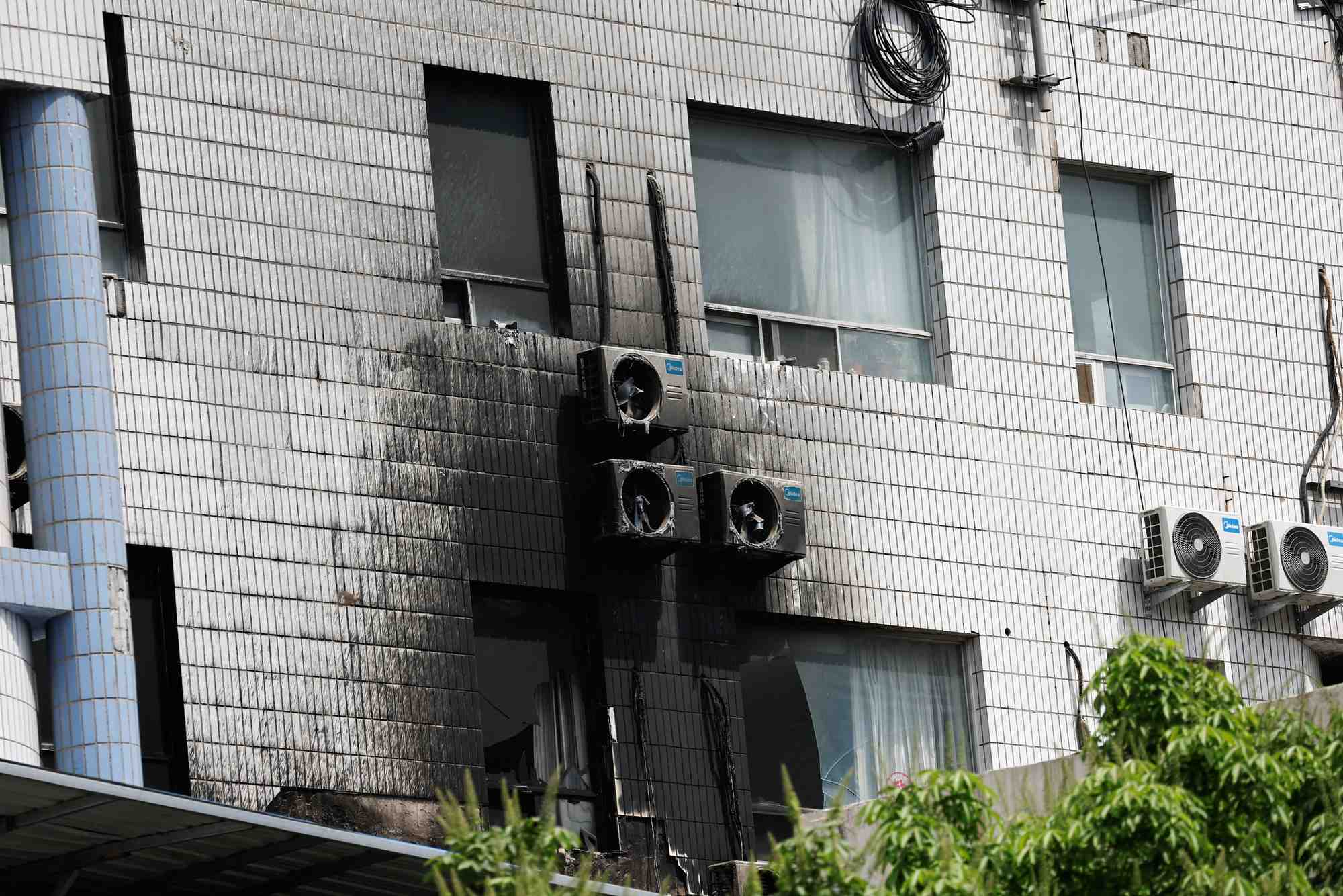 Photo de fenetres endommagees et de ventilateurs de climatisation externes a la suite d'un incendie survenu a l'hopital de changfeng, a pekin