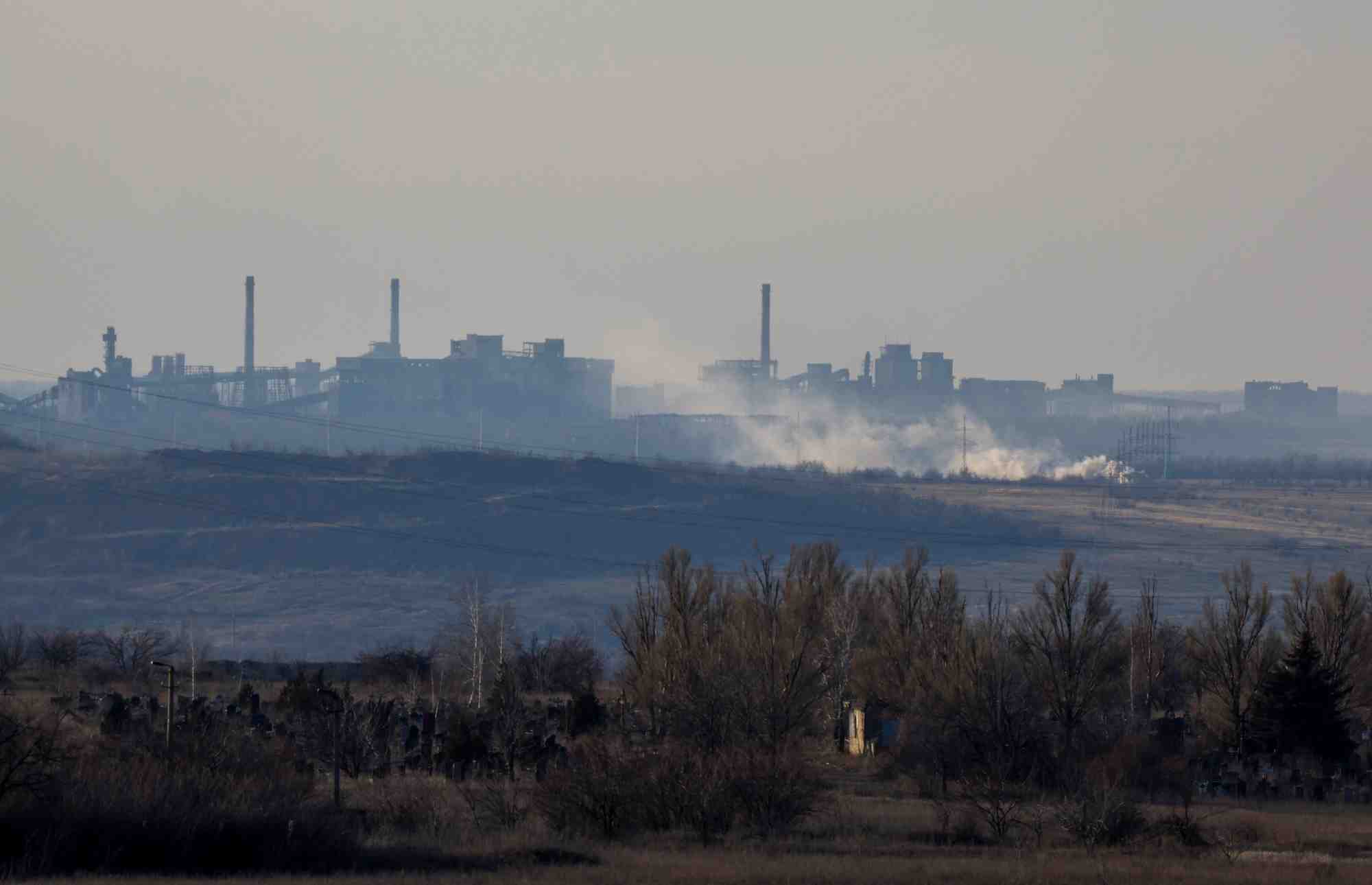 De la fumee s'eleve pres de l'usine de coke et de produits chimiques d'avdiivka, vue de yasynuvata, dans la region de donetsk