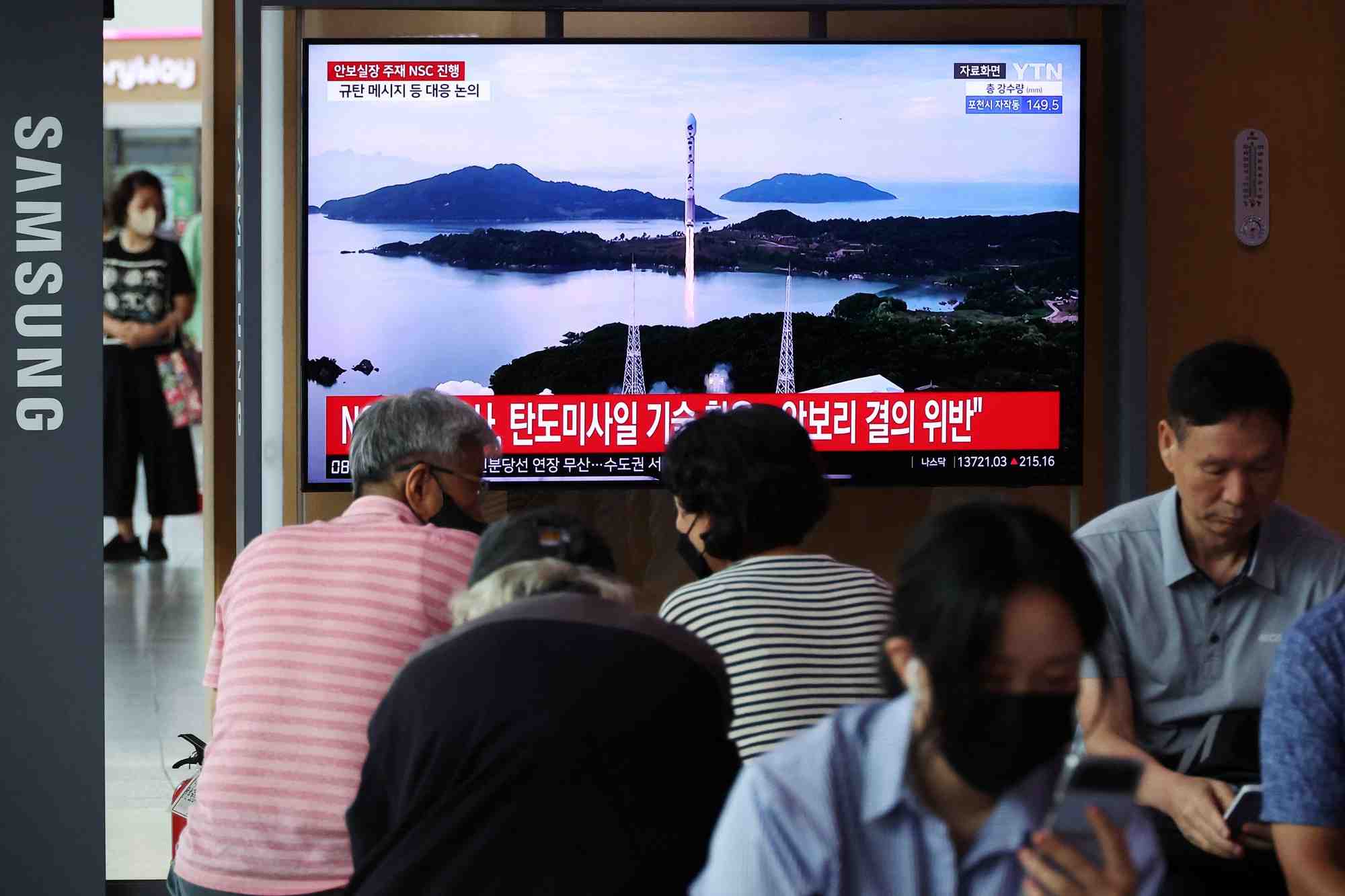 Photo des gens qui regardent un reportage sur le lancement d'un satellite effectue par la coree du nord
