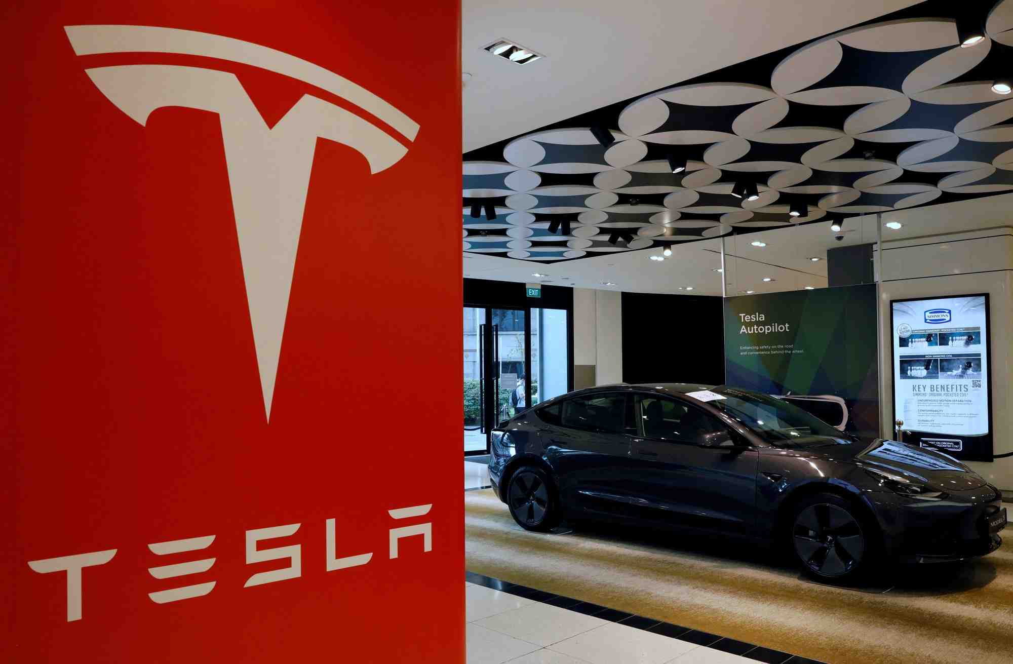 Une voiture tesla modele 3 est vue dans une salle d'exposition a singapour