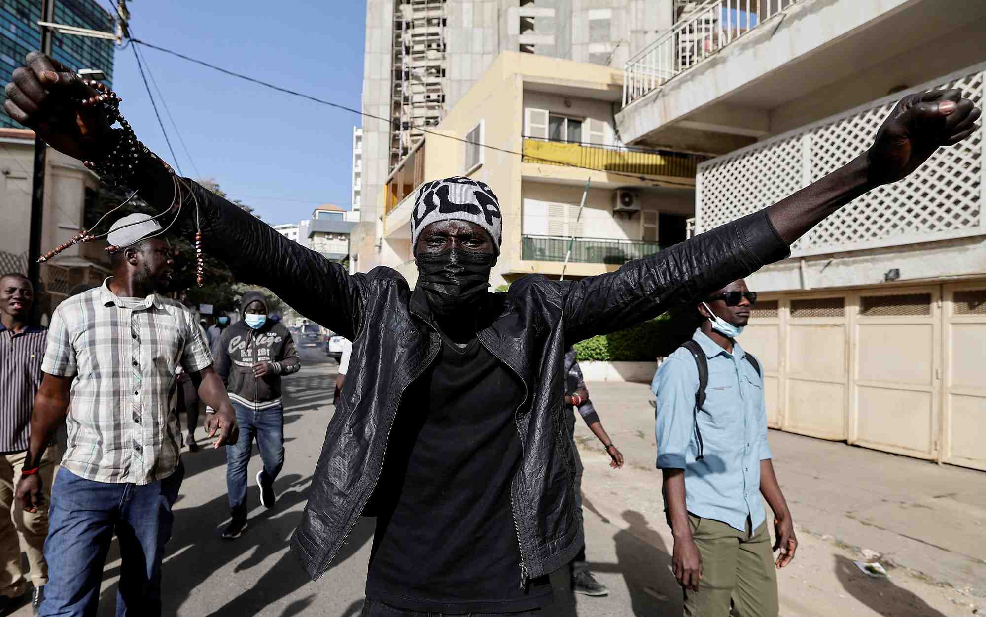 Photo de manifestants senegalais qui marchent apres avoir ete repousses par la police anti-emeute alors qu'ils tentaient de se rassembler pour protester contre le report de l'election presidentielle