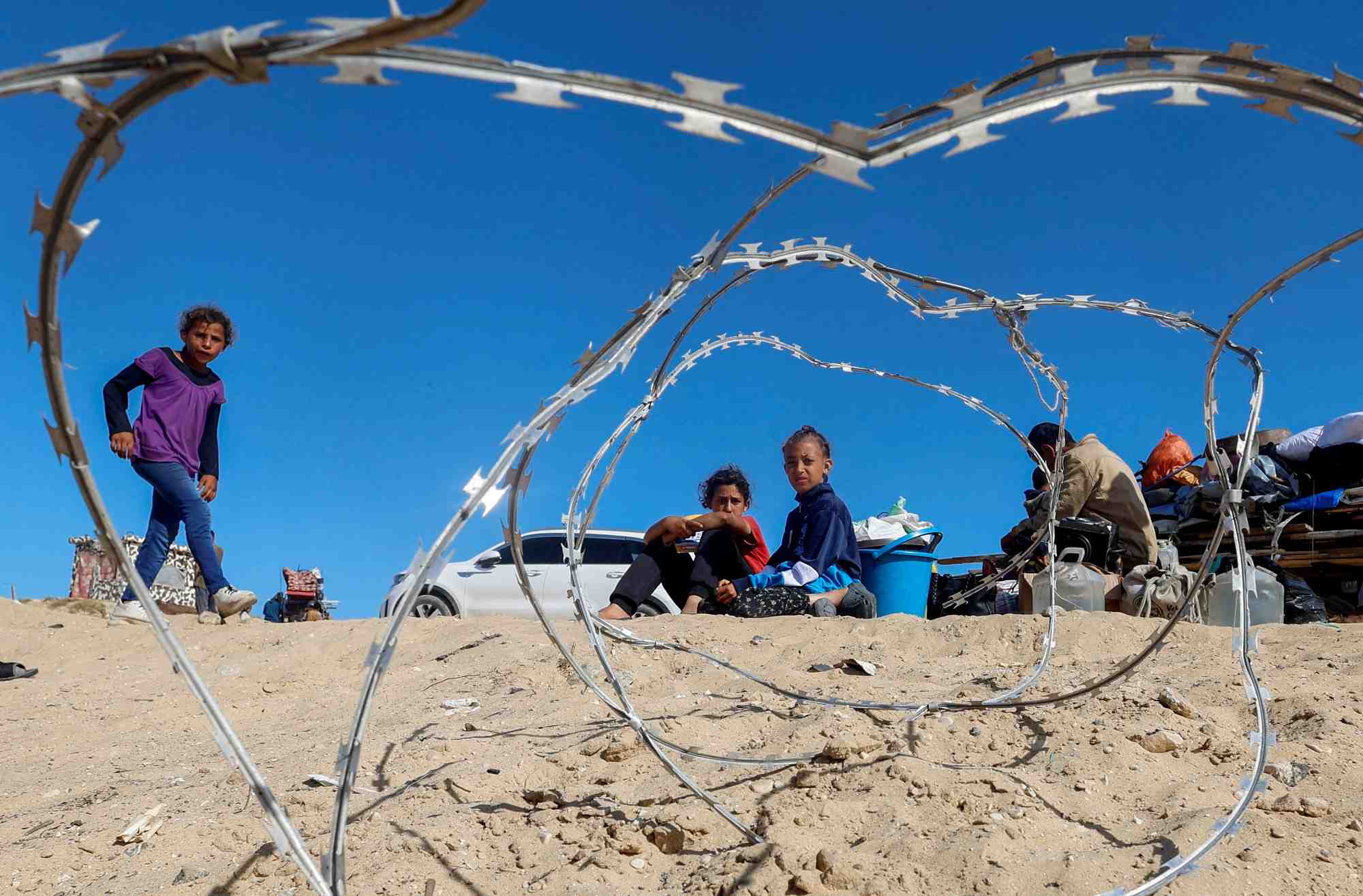 Photo d'archives des palestiniens assis a cote de leurs biens alors que les gens fuient rafah