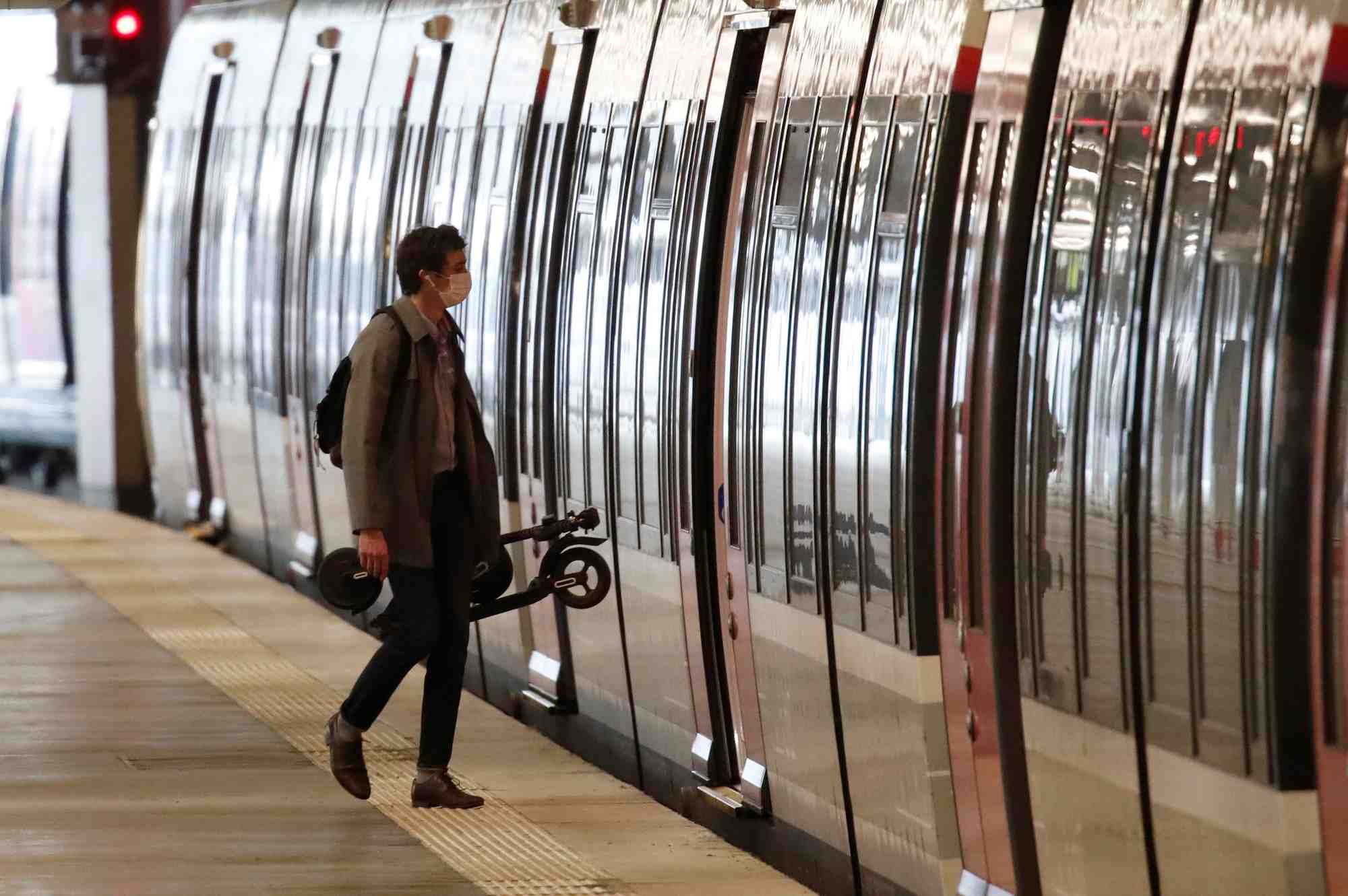 Transports : un homme portant un masque s'apprête à entrer dans un RER en station Gare du Nord, à Paris, le 27 avril 2020