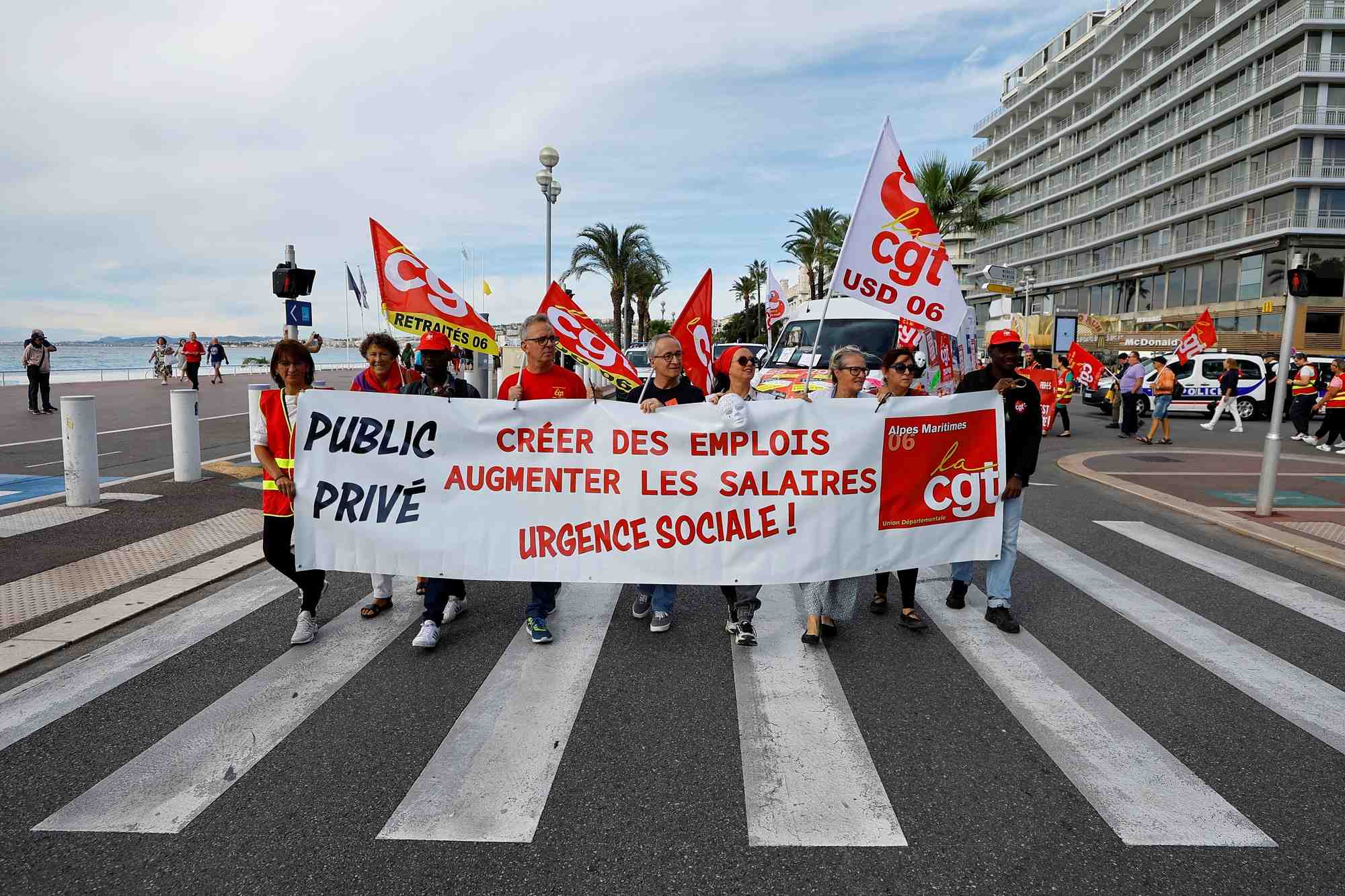 Des manifestant portent des drapeaux et une banderole de la cgt sur la promenade des anglais a nice
