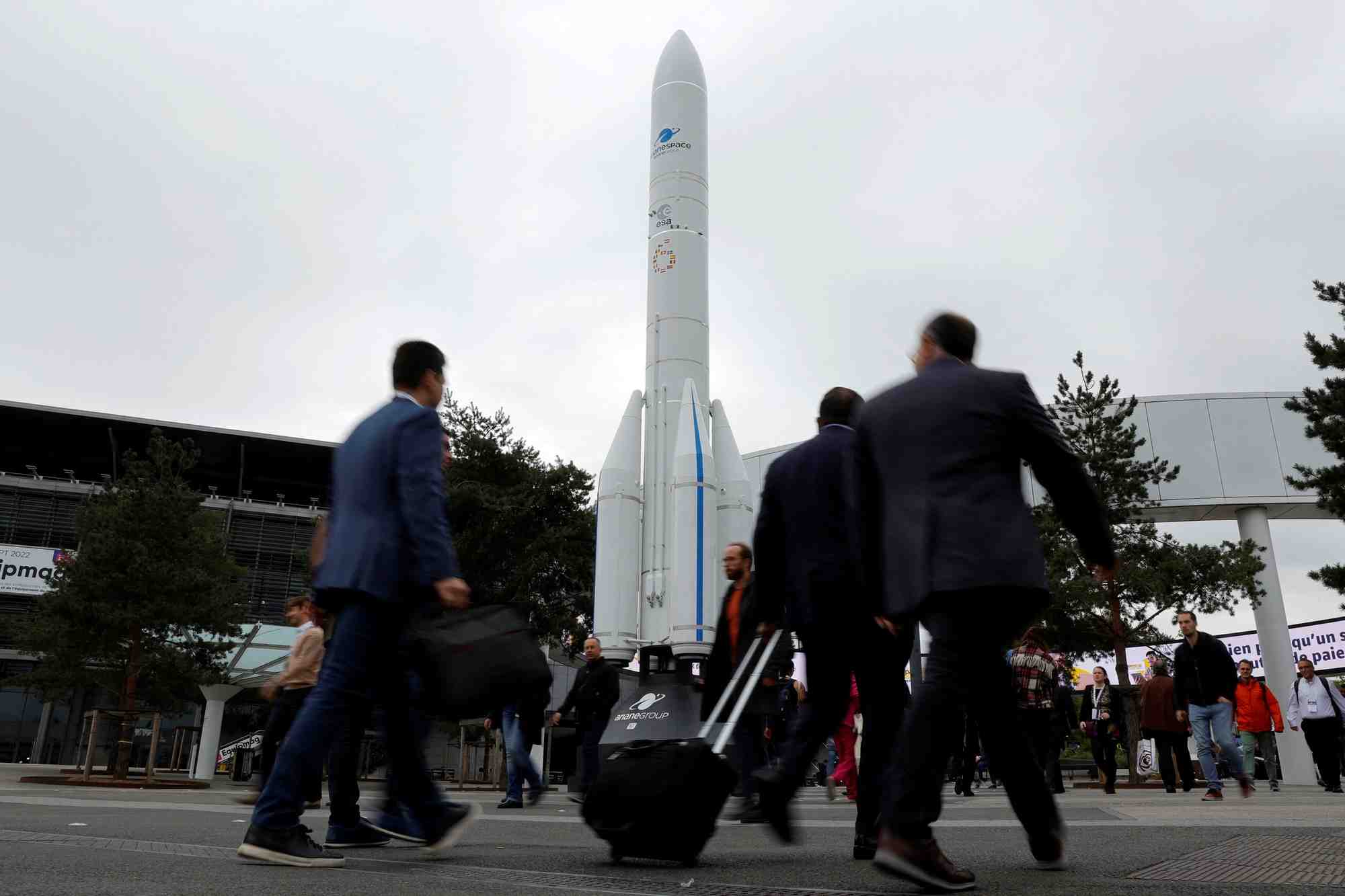 Des visiteurs passent devant la maquette d'une fusee a l'entree du congres international d'astronautique (iac) a paris