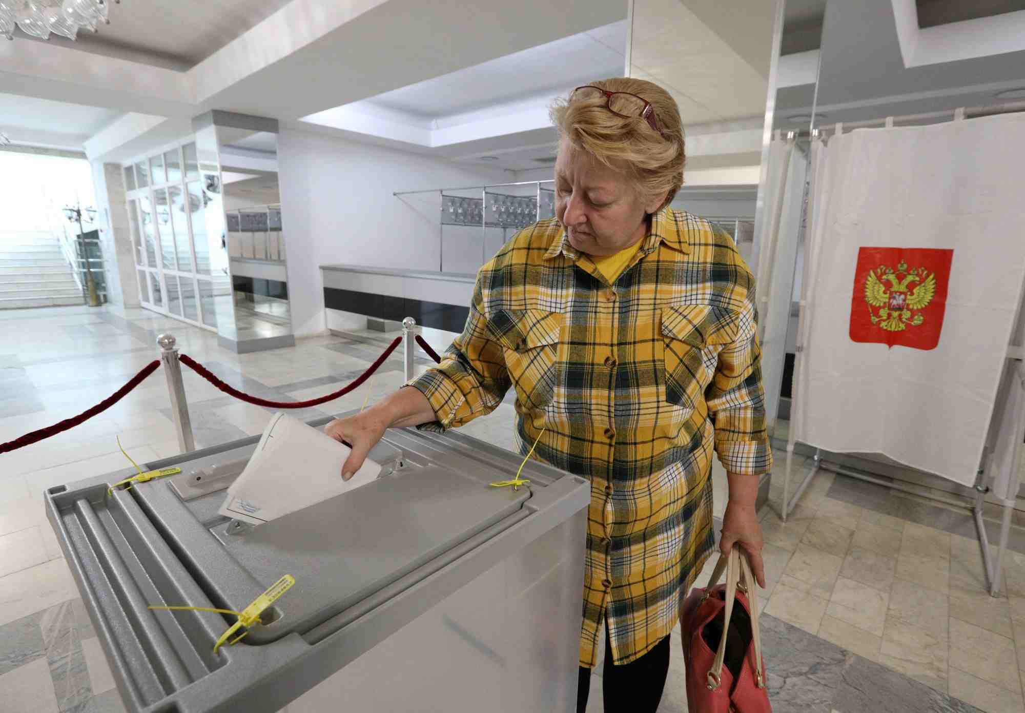 Une femme depose son bulletin de vote lors du premier jour d'un referendum sur le rattachement a la russie des regions d'ukraine controlees par la russie, a sebastopol, en crimee