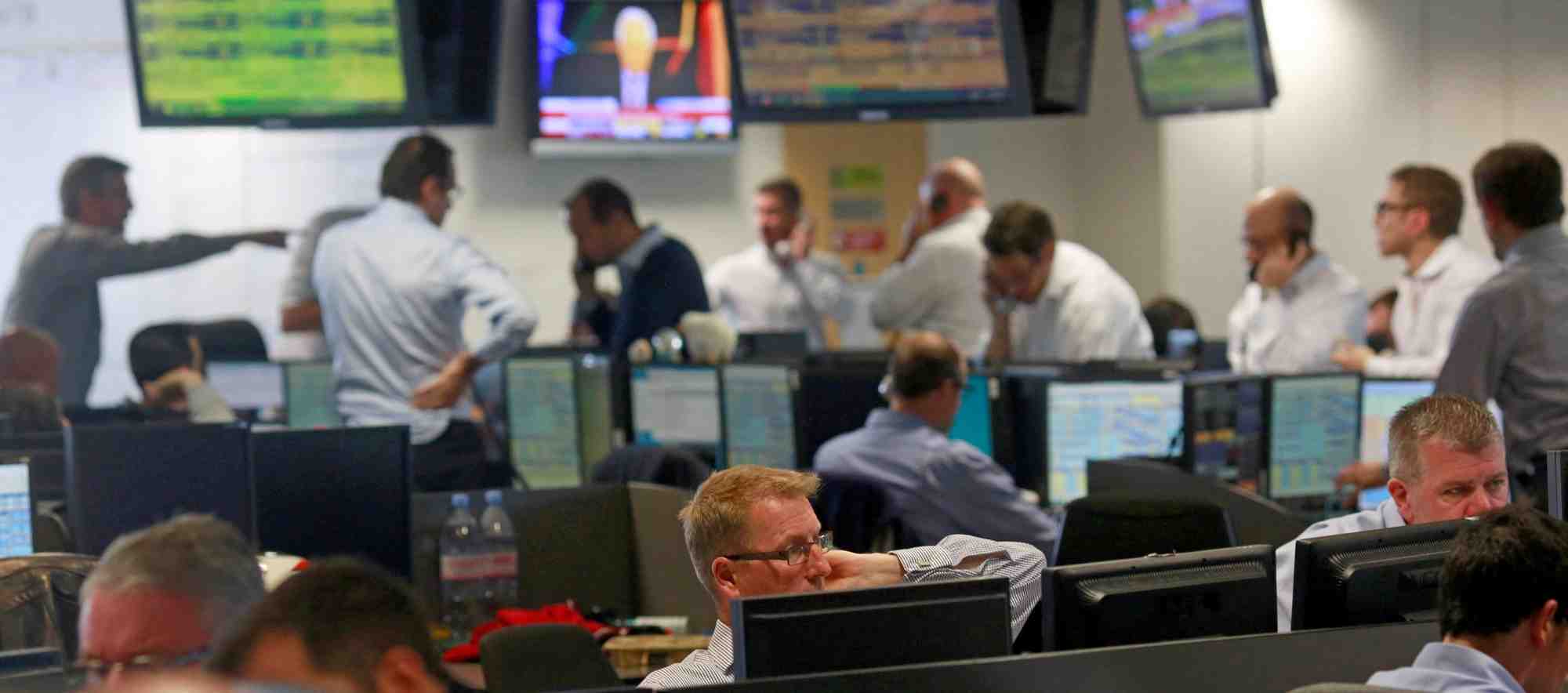Traders from bgc, a global brokerage company in london's canary wharf financial centre react as european stock markets open