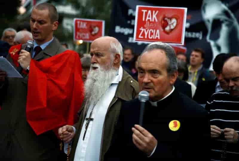 People pray as they take part in an anti-abortion demonstration in front of the parliament in warsaw