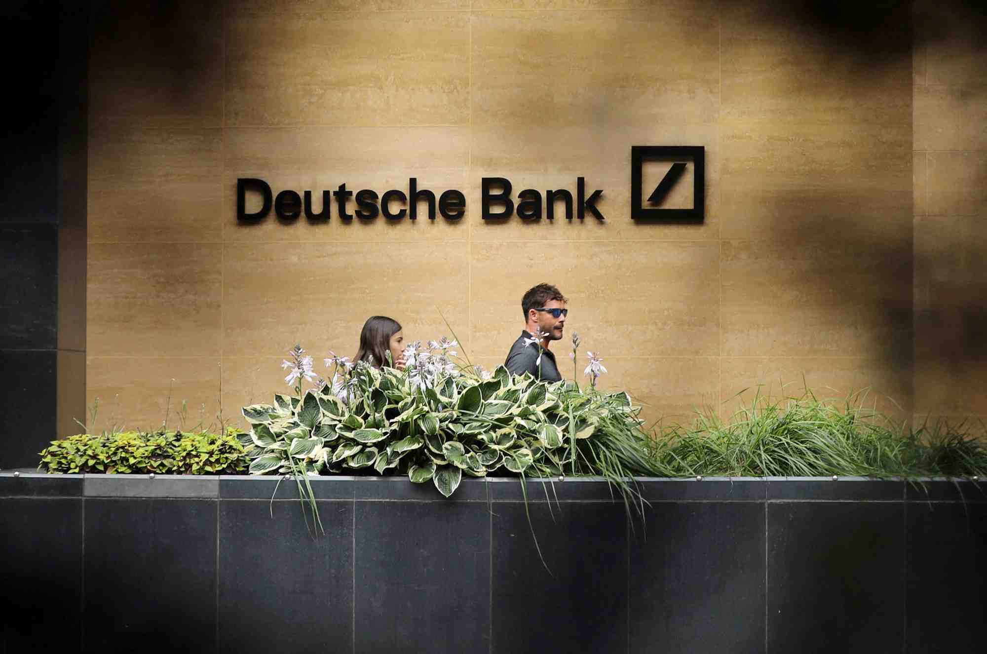 Des personnes passent devant un bureau de la deutsche bank a londres