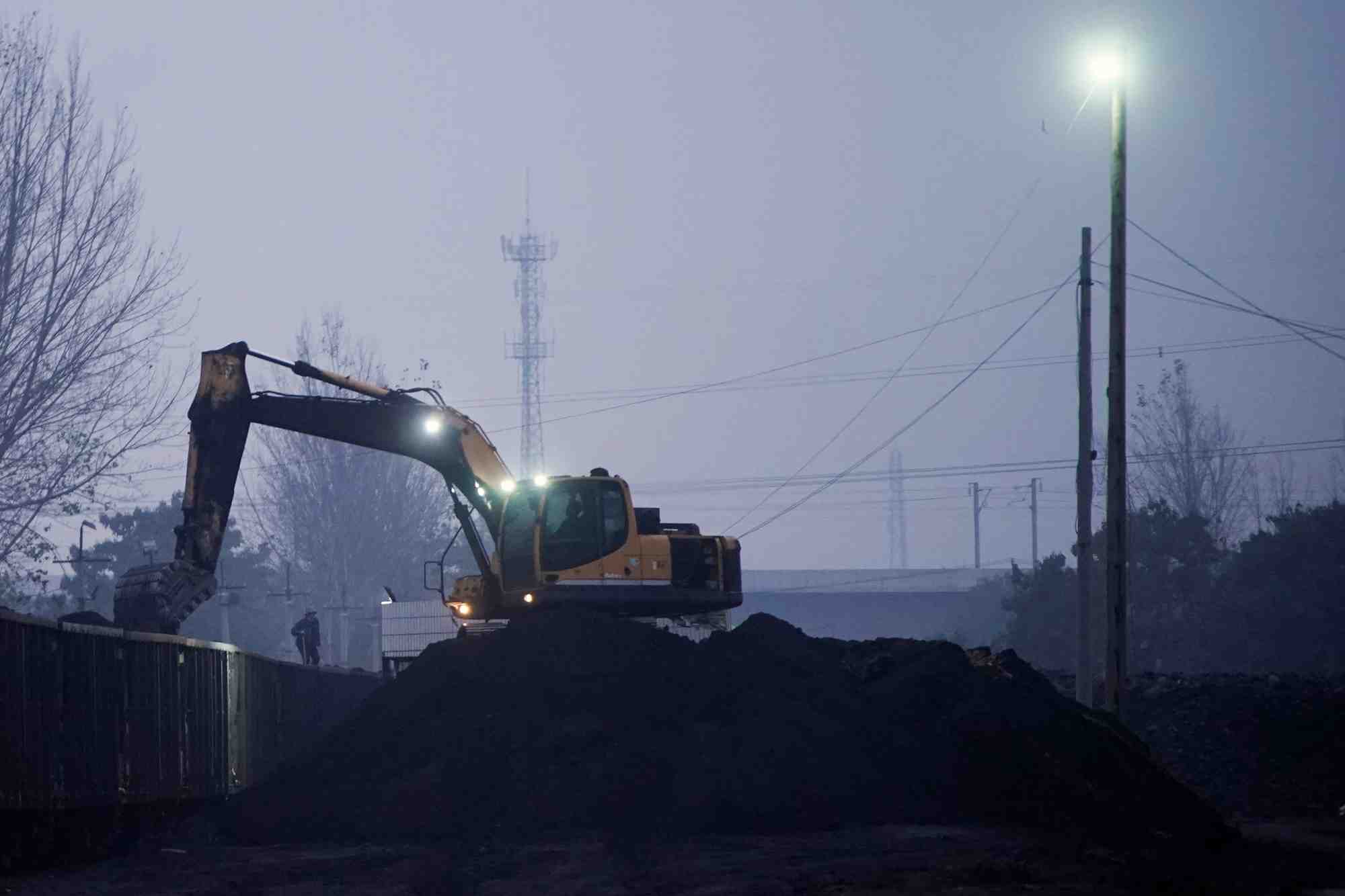 Une pelleteuse charge du charbon dans un train a pingdingshan, en chine