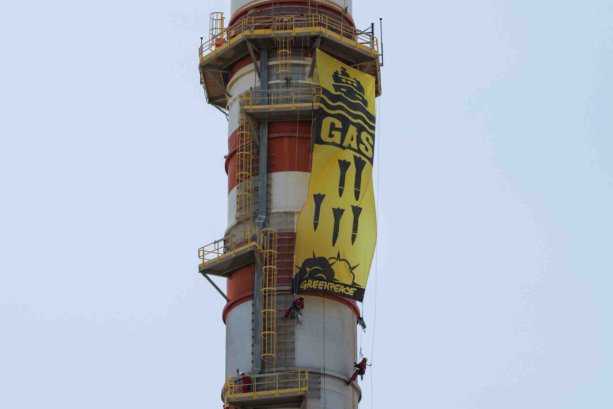 Des militants de greenpeace affichent une banniere suspendue a une cheminee lors d'une manifestation contre l'entreprise energetique naturgy, a campanillas