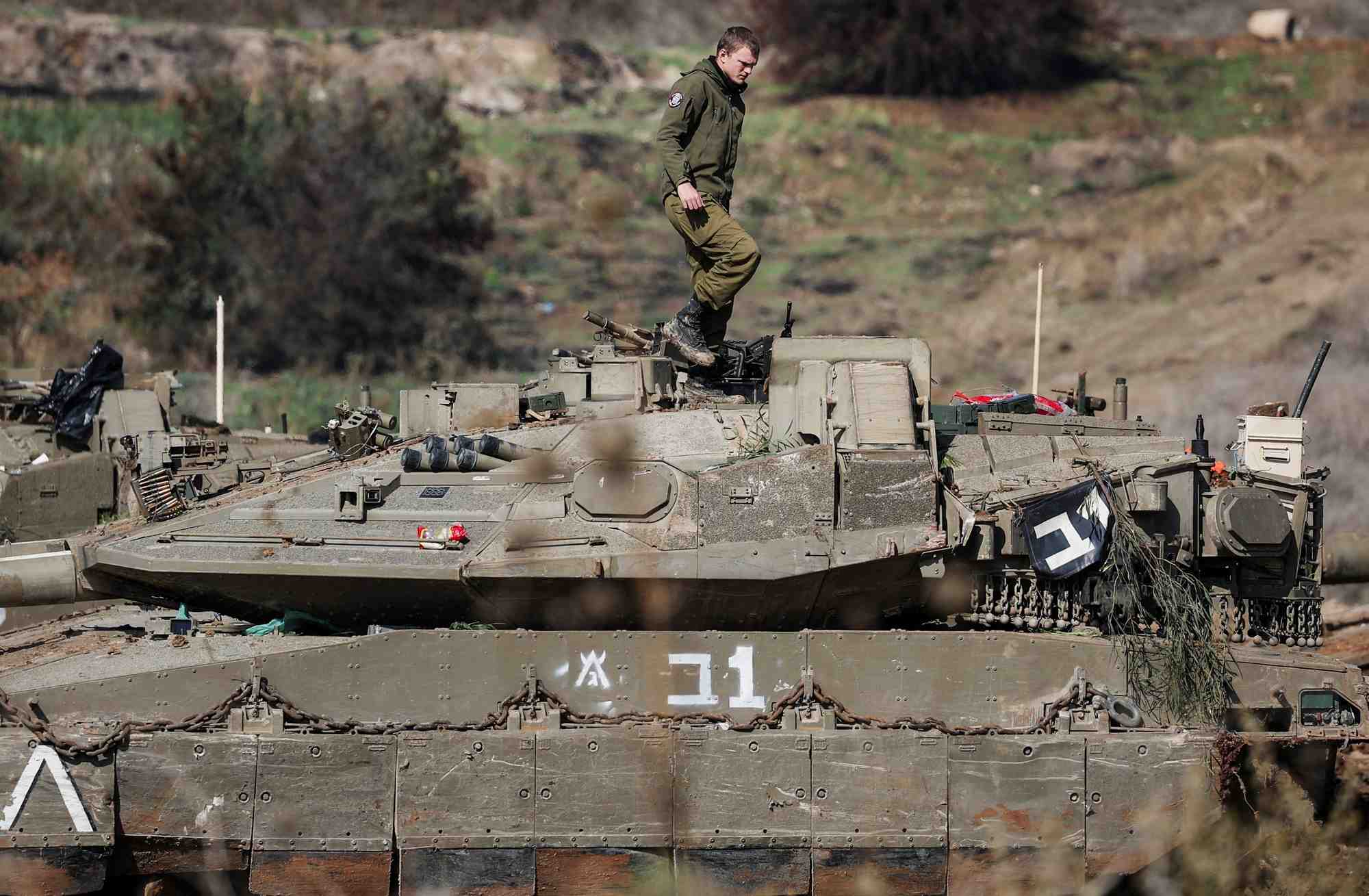 Un soldat israelien se tient sur un vehicule militaire en position d'attente proche de la frontiere israelo-libanaise