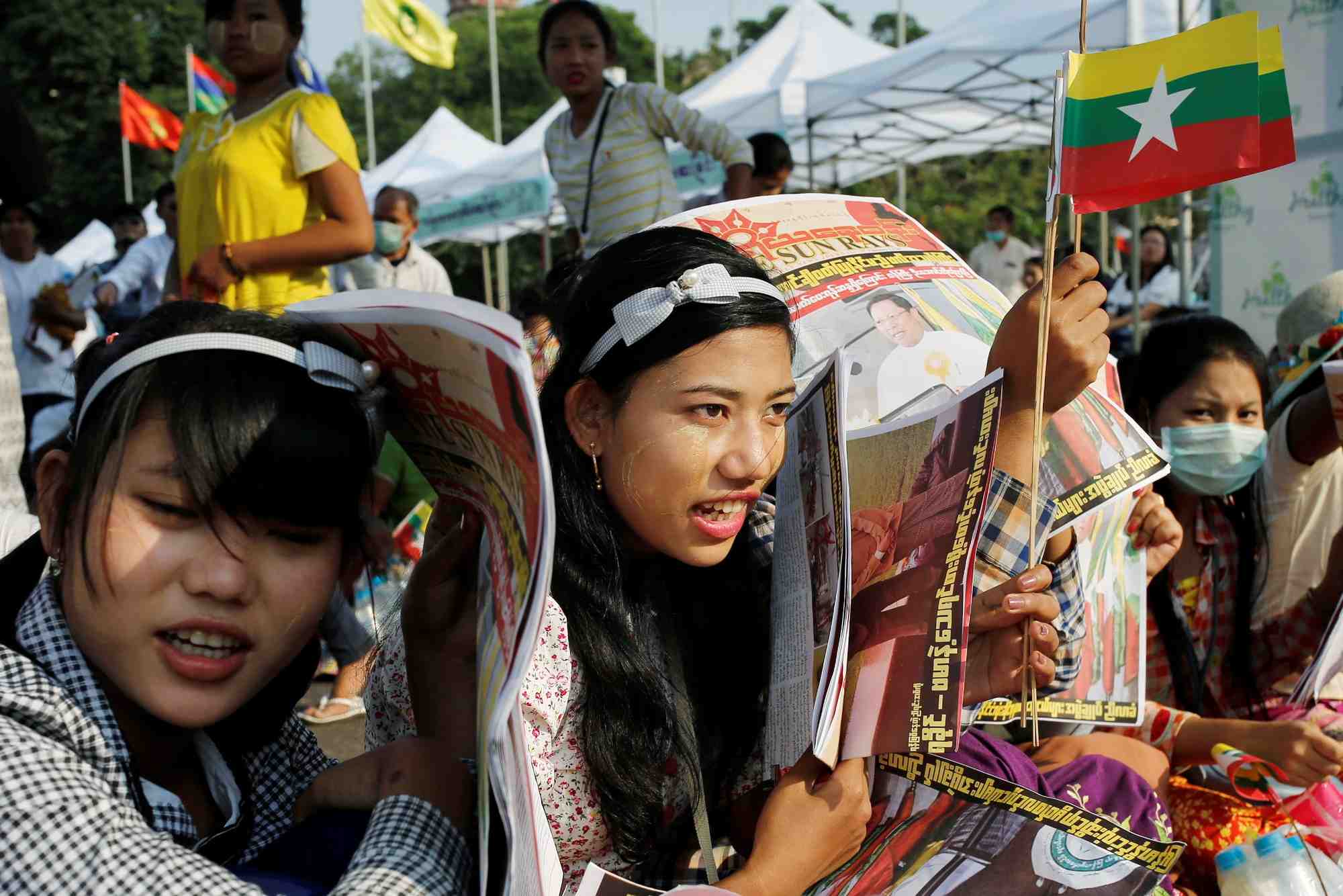 Des participants portent des drapeaux du myanmar lors d'un rassemblement nationaliste a yangon