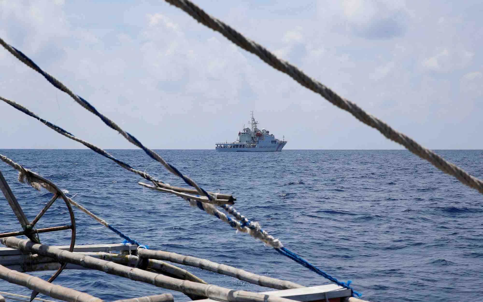 Un navire des garde-cotes chinois est vu depuis un bateau de peche philippin