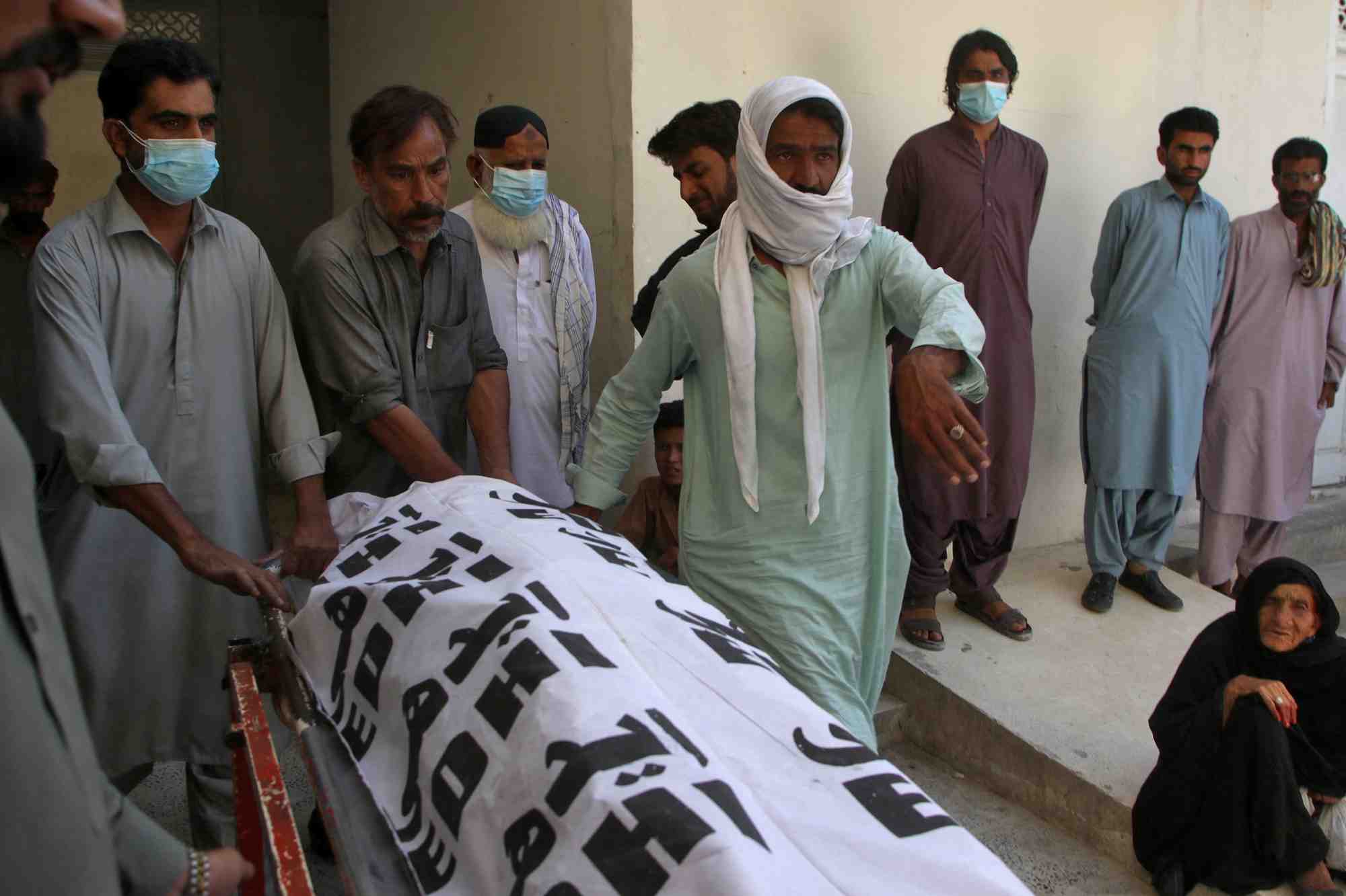 Des personnes portent le corps d'une victime tuee lors des attaques au balochistan.
