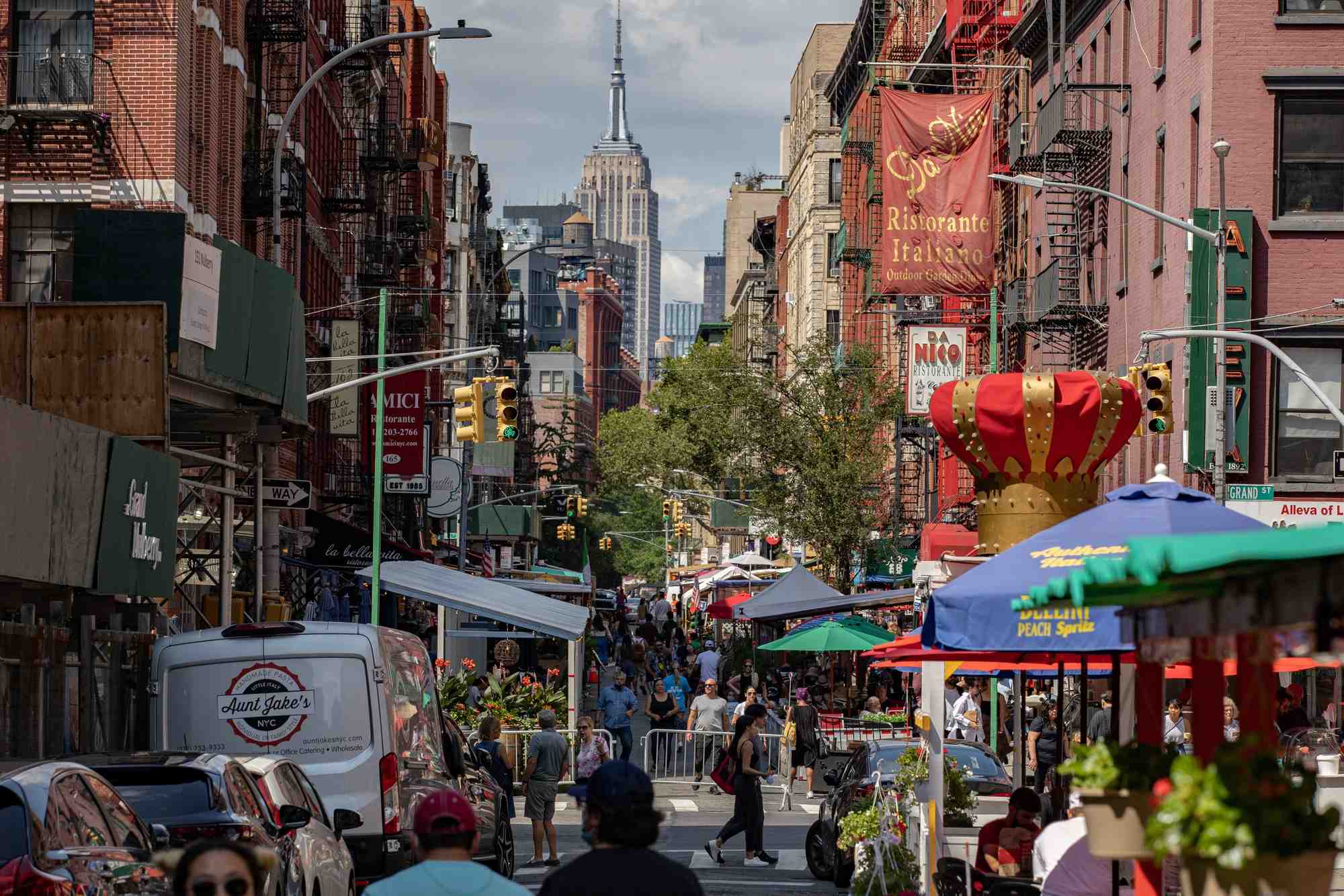 Des gens marchent dans une rue bordee de restaurants dans le quartier de little italy a manhattan