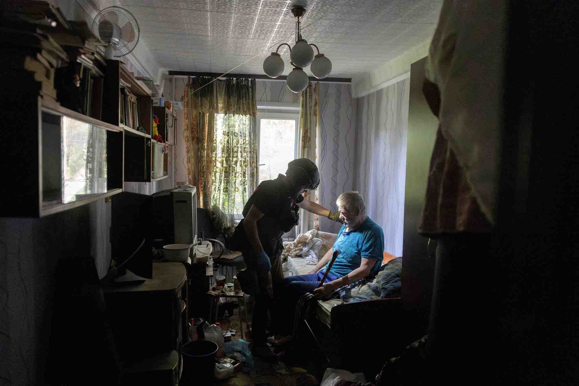 Un volontaire aide un habitant qui evacue sa maison en raison des avancees russes a selydove, pres de pokrovsk