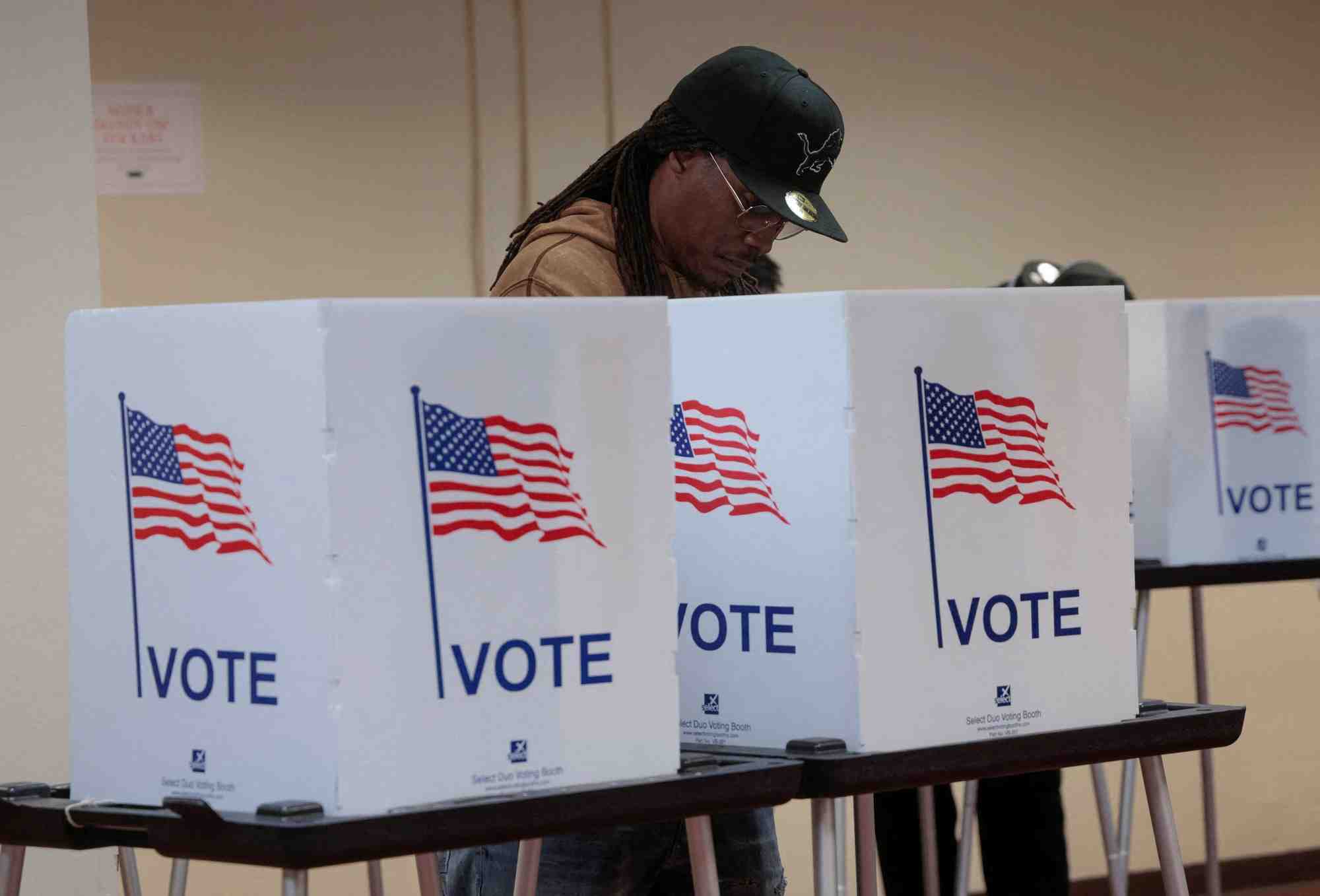 Des electeurs deposent leurs bulletins lors du vote anticipe pour l'election presidentielle americaine dans un bureau de vote