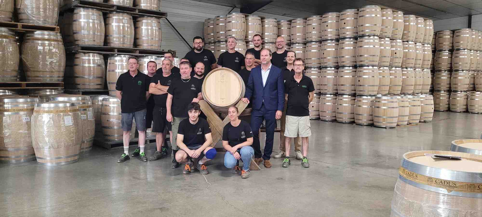 Les tonneliers de Cadus et leur directeur, Benjamin Le Berre, entourent le premier fut entièrement fabriqué à partir de matières premières issues de la Bourgogne.