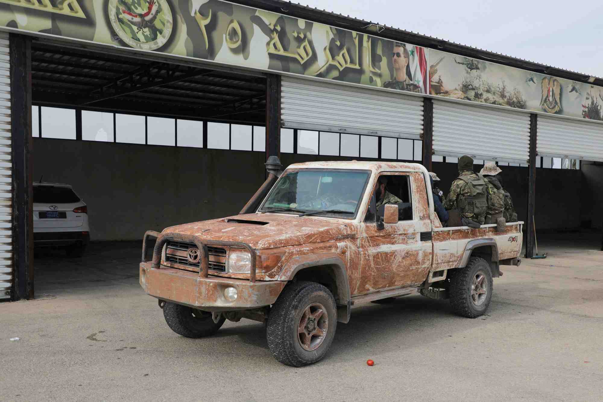 Des combattants rebelles sont assis a l'arriere d'un vehicule dans la campagne de homs, en syrie, le 7 decembre 2024