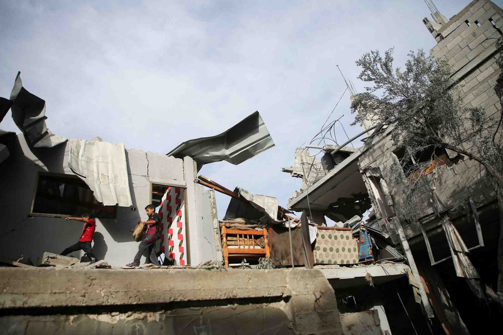 Des enfants palestiniens inspectent le site d'une frappe israelienne sur une maison a rafah