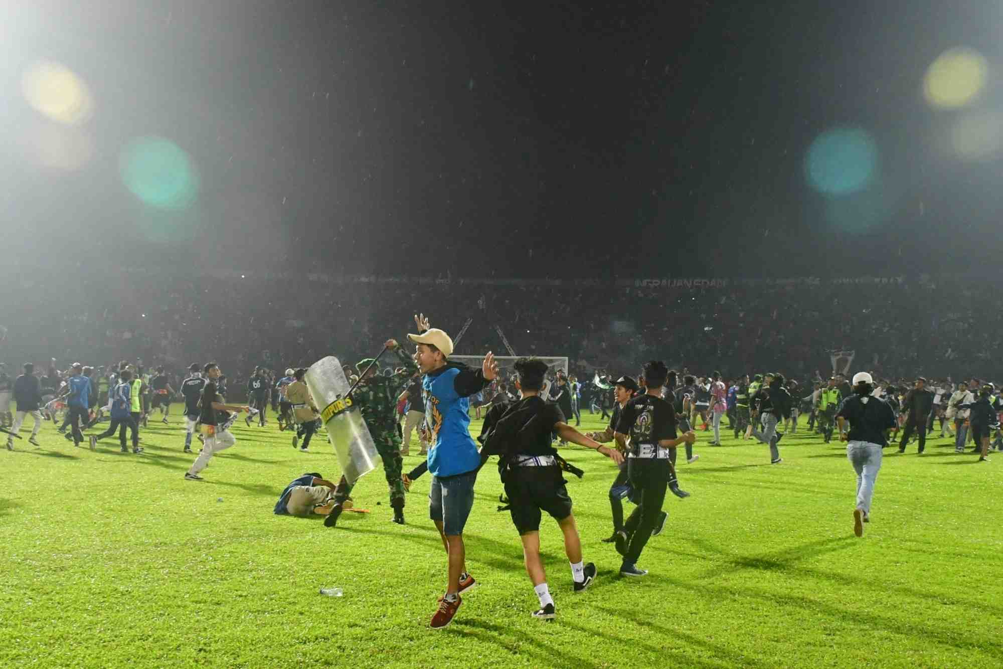 Des supporters entrent sur le terrain pendant l'emeute qui a suivi le match de football entre arema vs persebaya au stade kanjuruhan