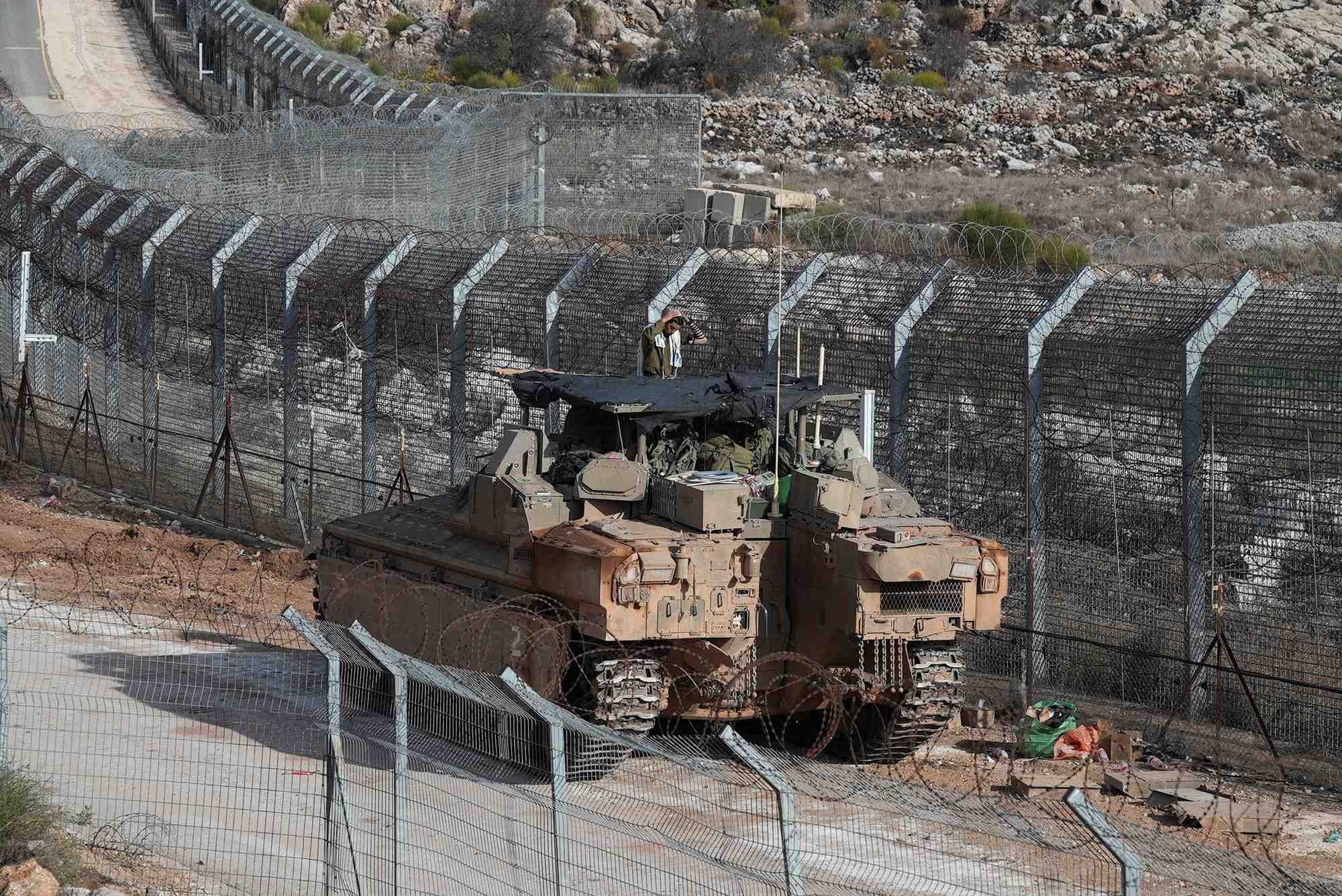 Un soldat israelien fait sa priere du matin sur un vehicule blinde de transport de troupes namer, le long de la ligne de cessez-le-feu entre la syrie et le plateau du golan occupe par israel