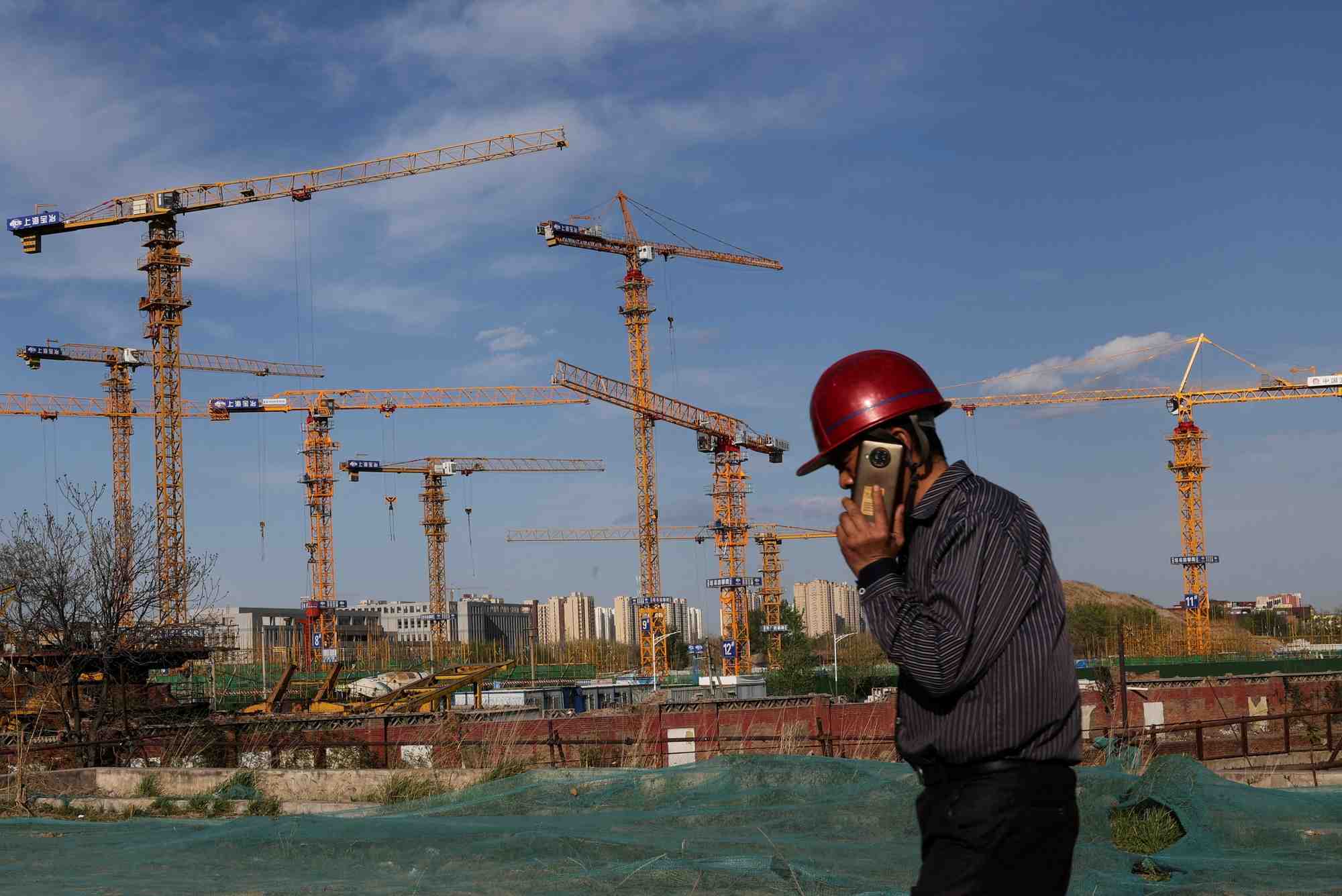 Un ouvrier passe devant un chantier de construction a pekin