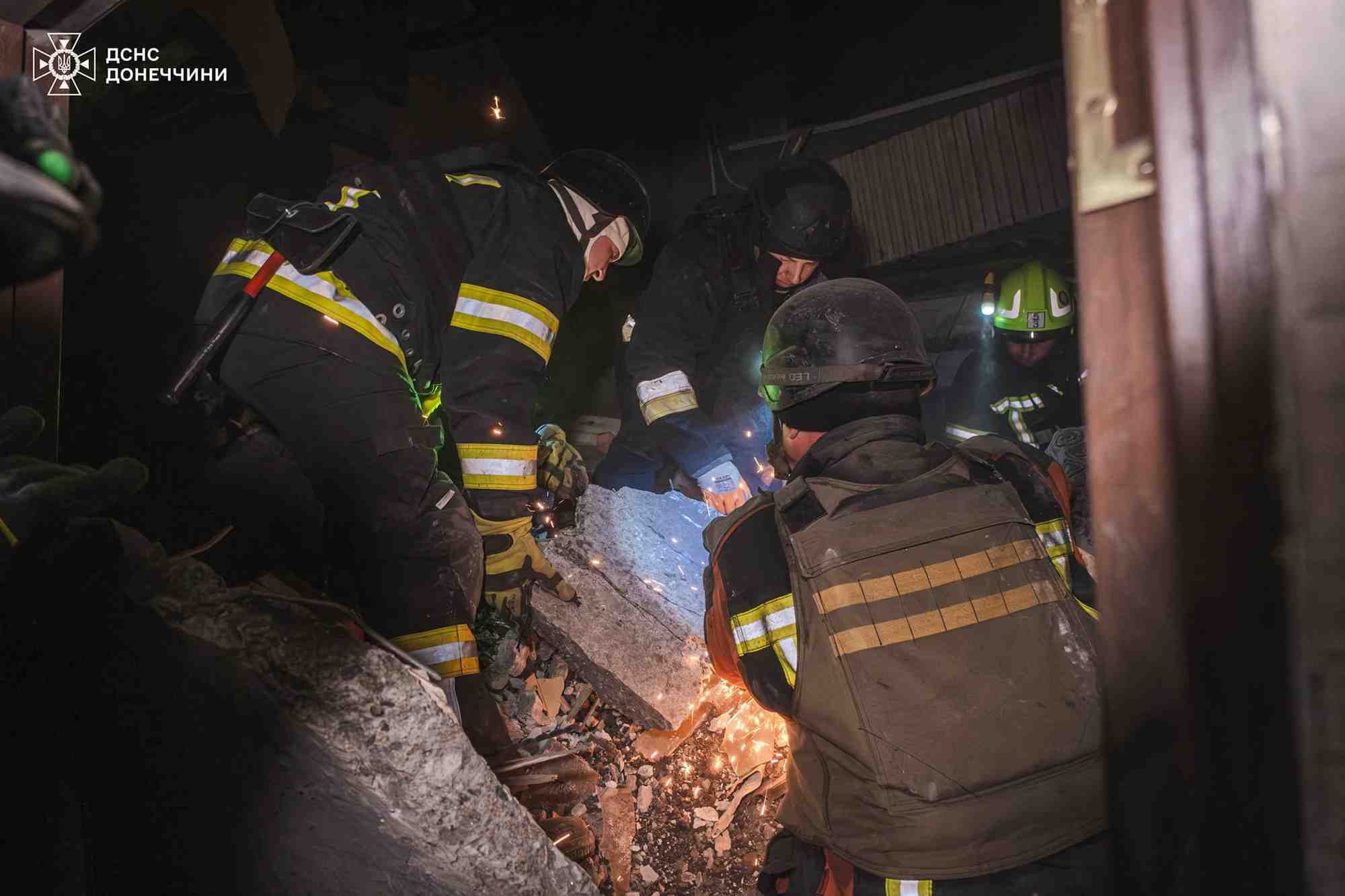 Des pompiers sur le site d'un immeuble touche par un tir de missile russe a myrnohrad, en ukraine