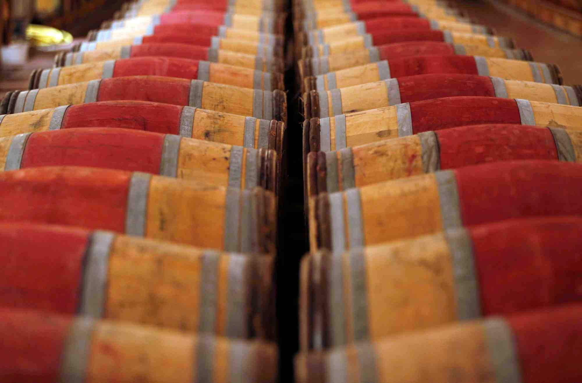 Photo de tonneaux de vin rouge stockes dans la cave du chateau domaine de chevalier a leognan, pres de bordeaux
