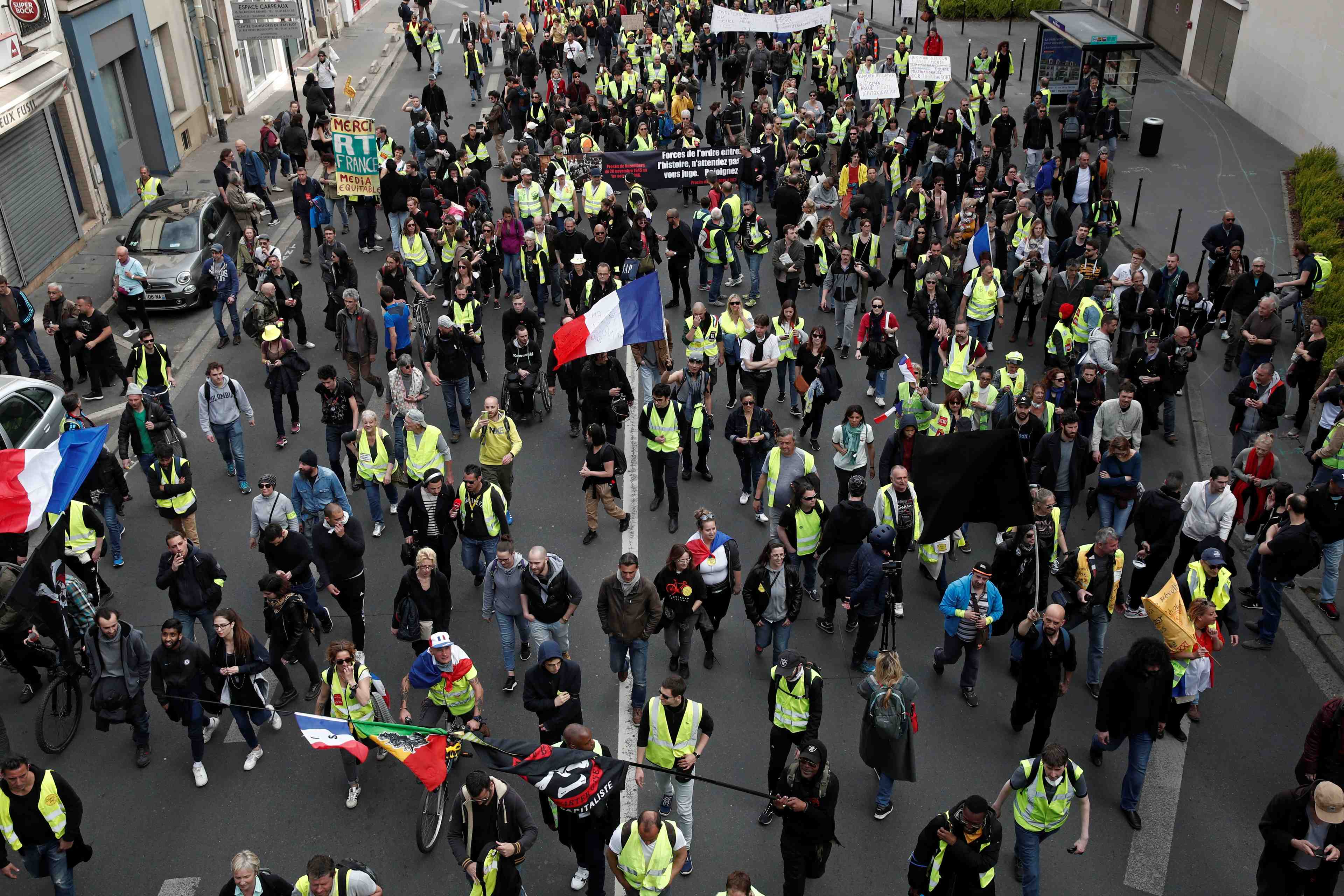 Protesters wearing yellow vests march on the pont de courbevoie during the act xxi (the 21st consecutive national protest on saturday) of the yellow vests movement in paris